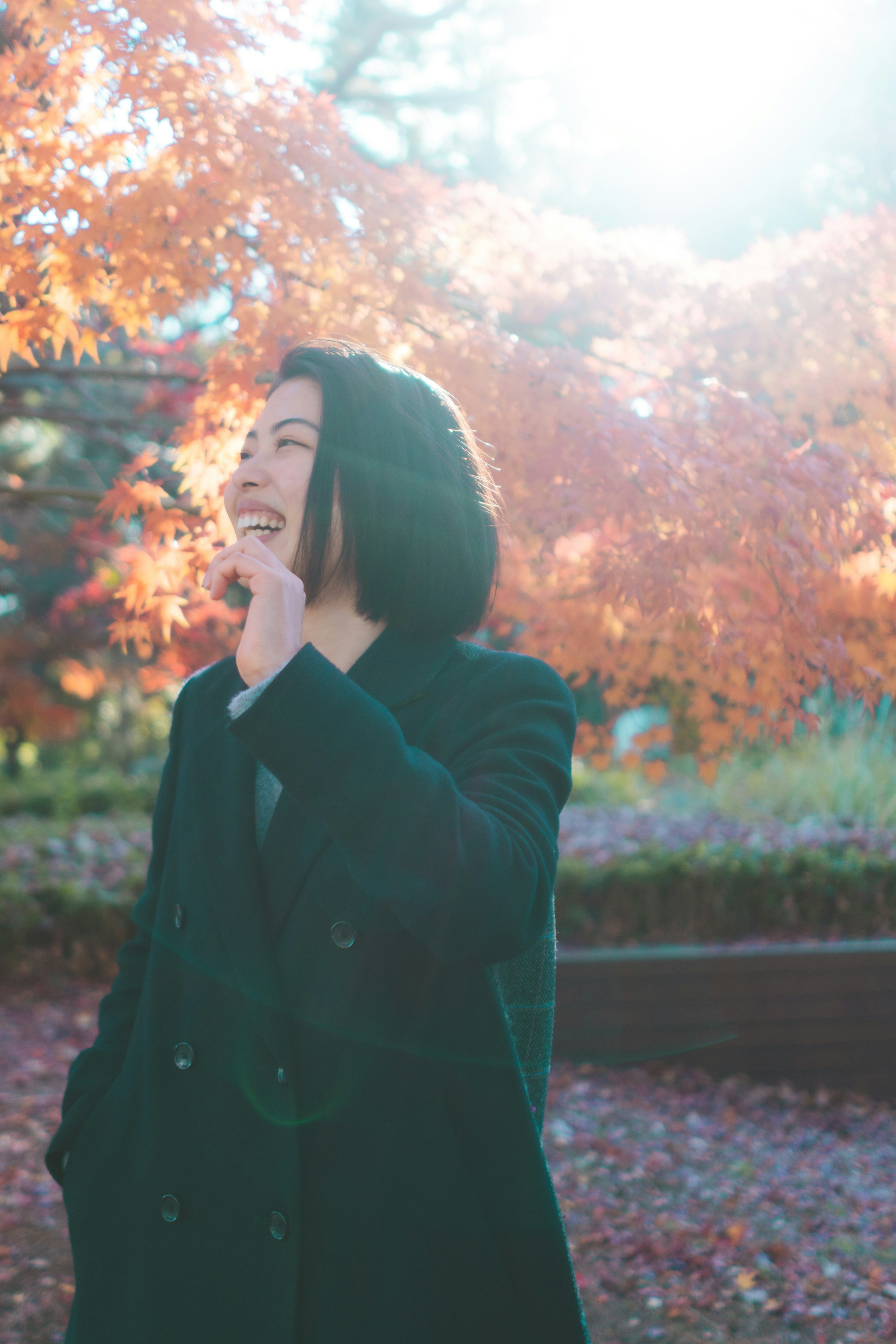 Jeune homme souriant dans le feuillage d'automne