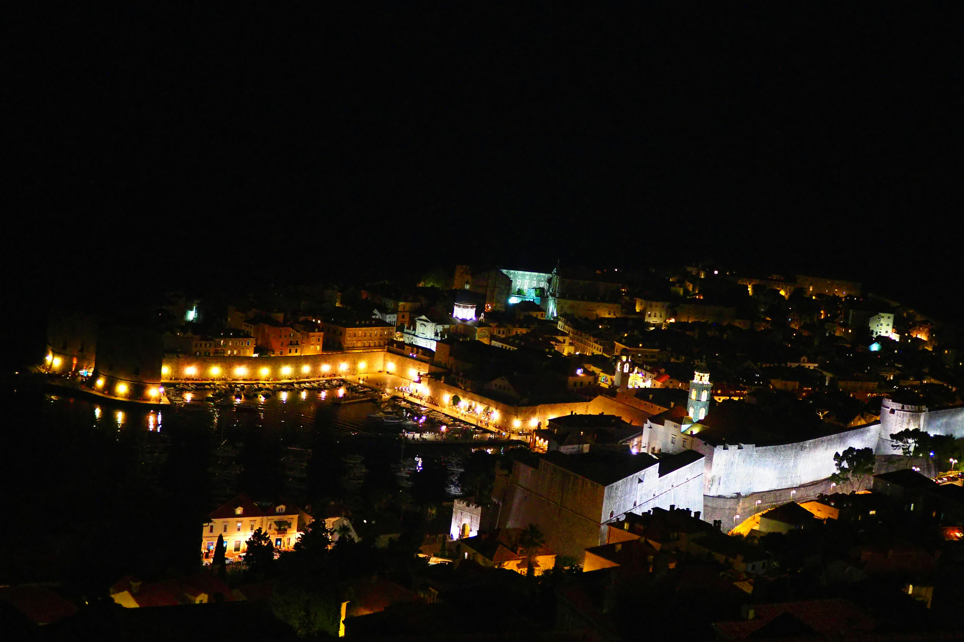 Magnifica vista notturna di Dubrovnik con edifici costieri illuminati