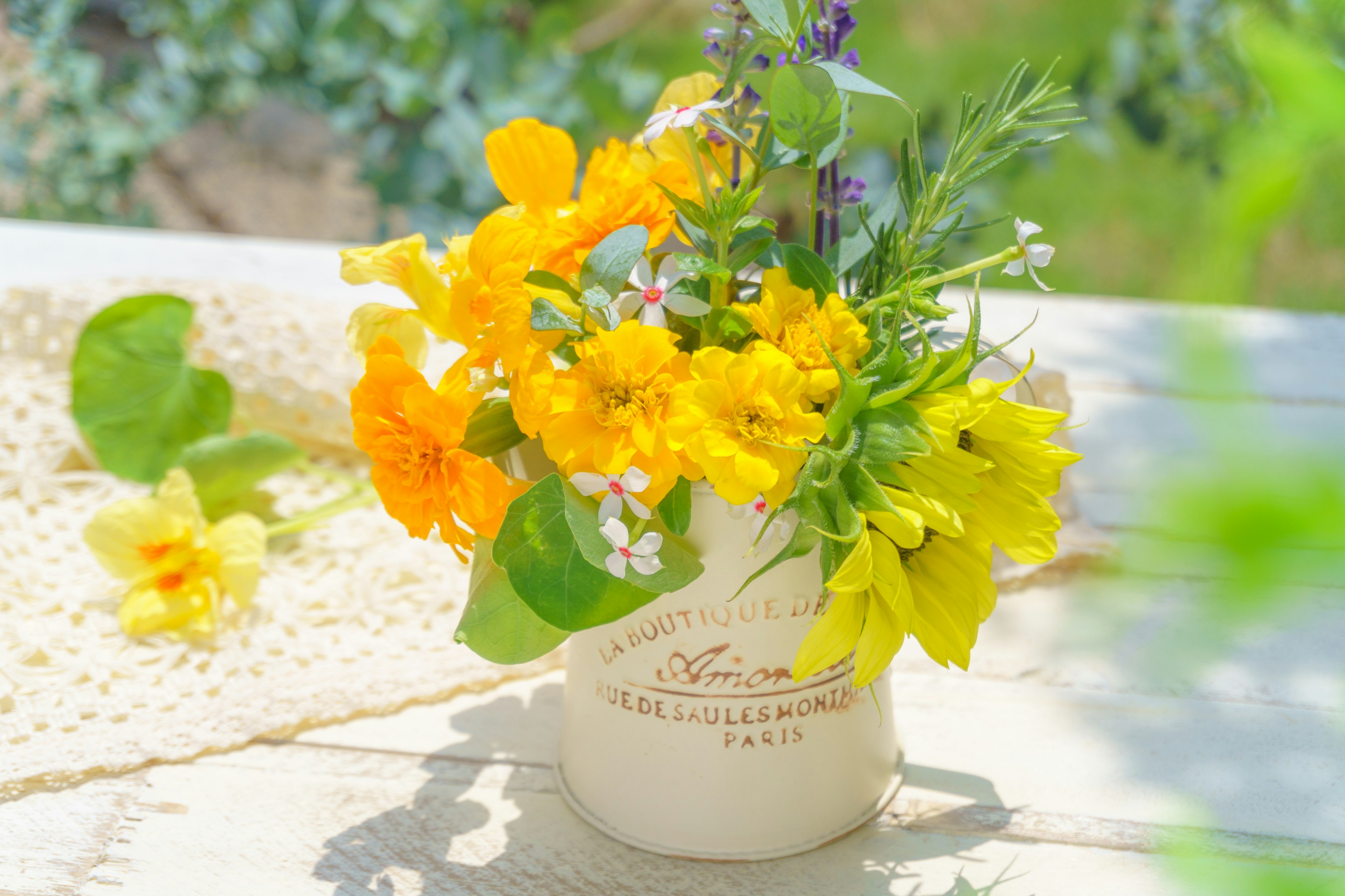 Un vase en céramique rempli de fleurs jaunes vives sur une table