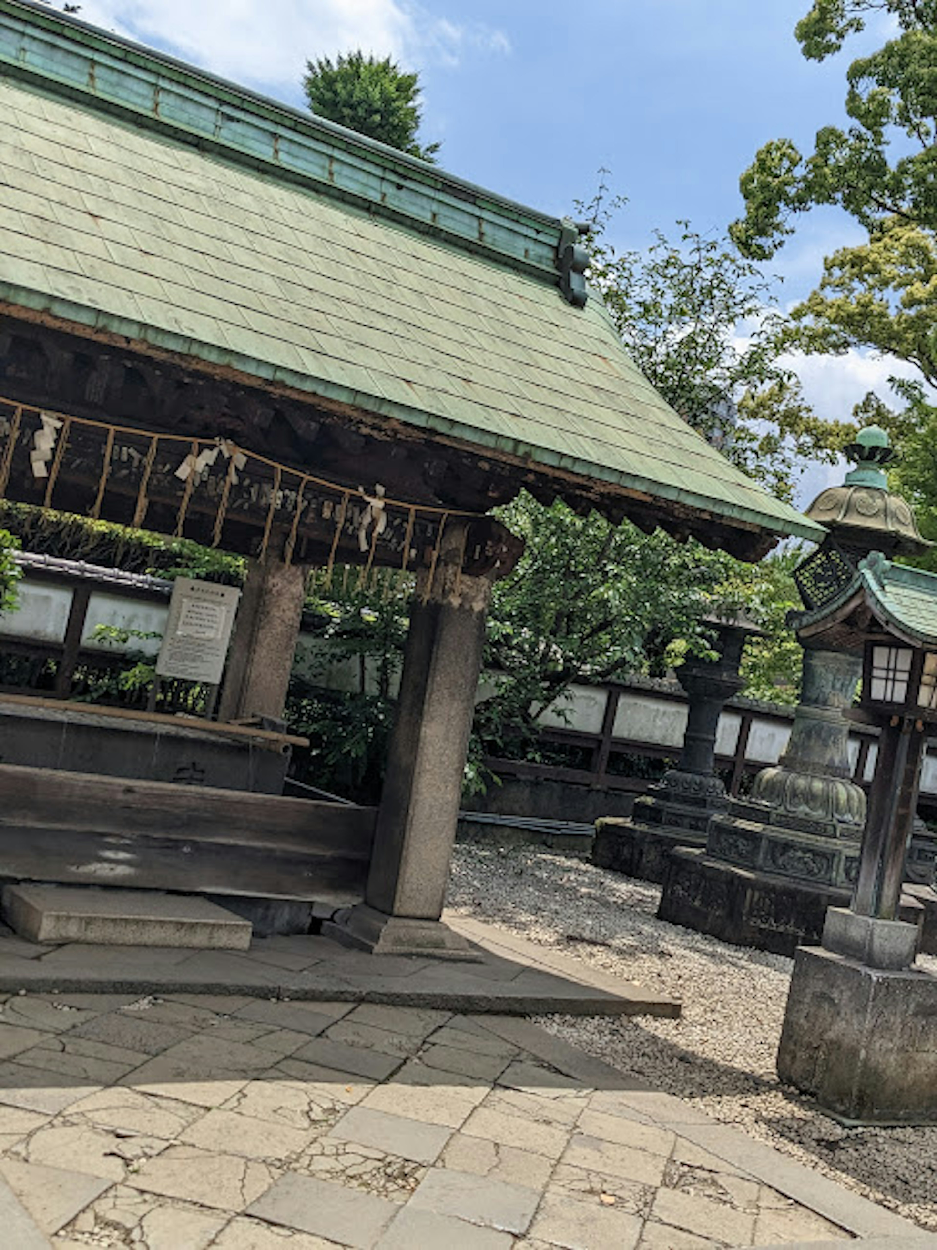 Shrine building with a green roof surrounded by nature