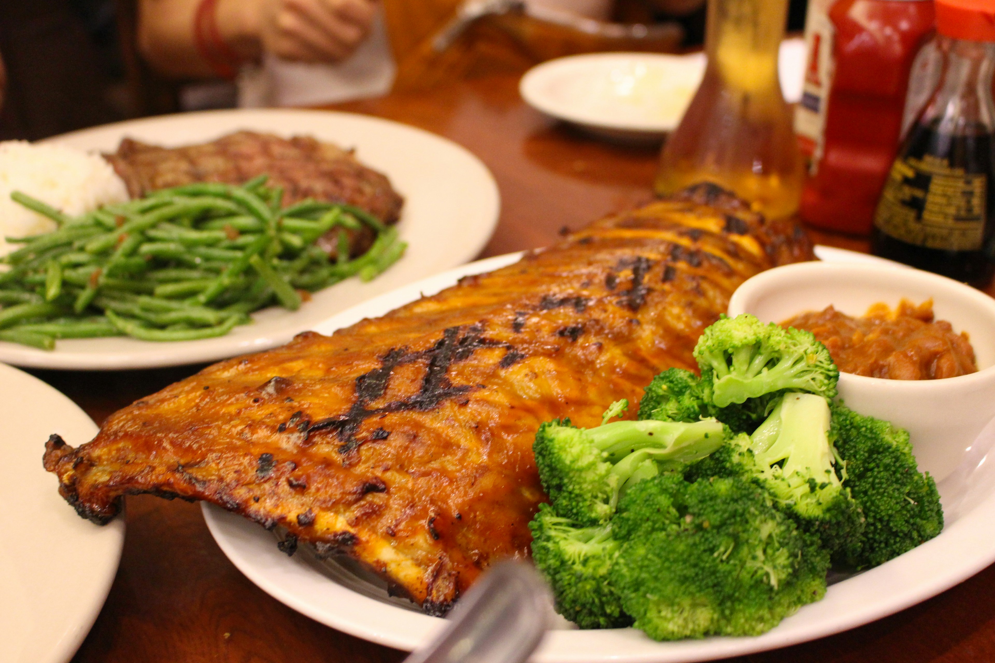 Grilled ribs with broccoli green beans baked beans served on a plate