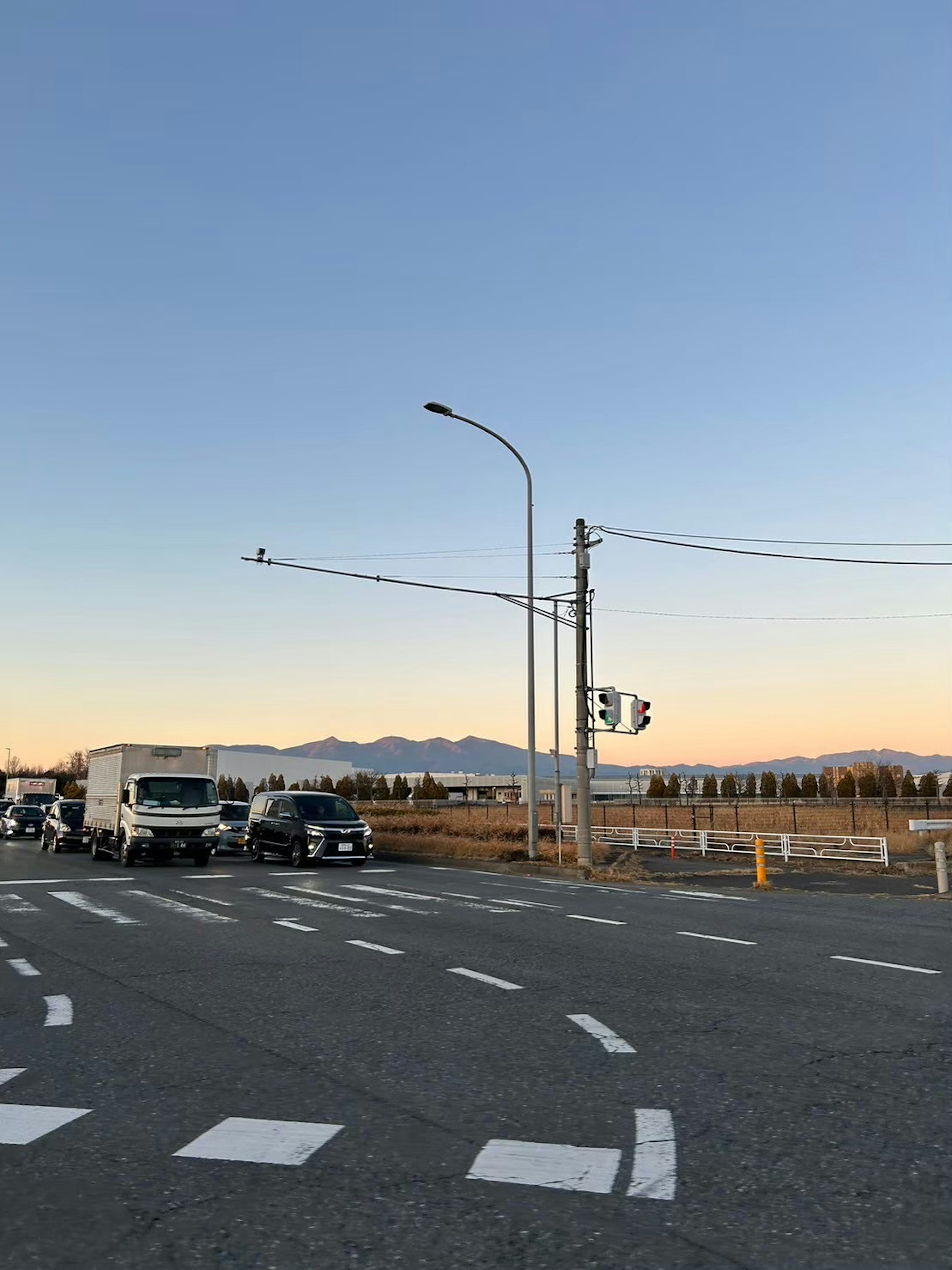 道路の交差点に停車中のトラックと青空