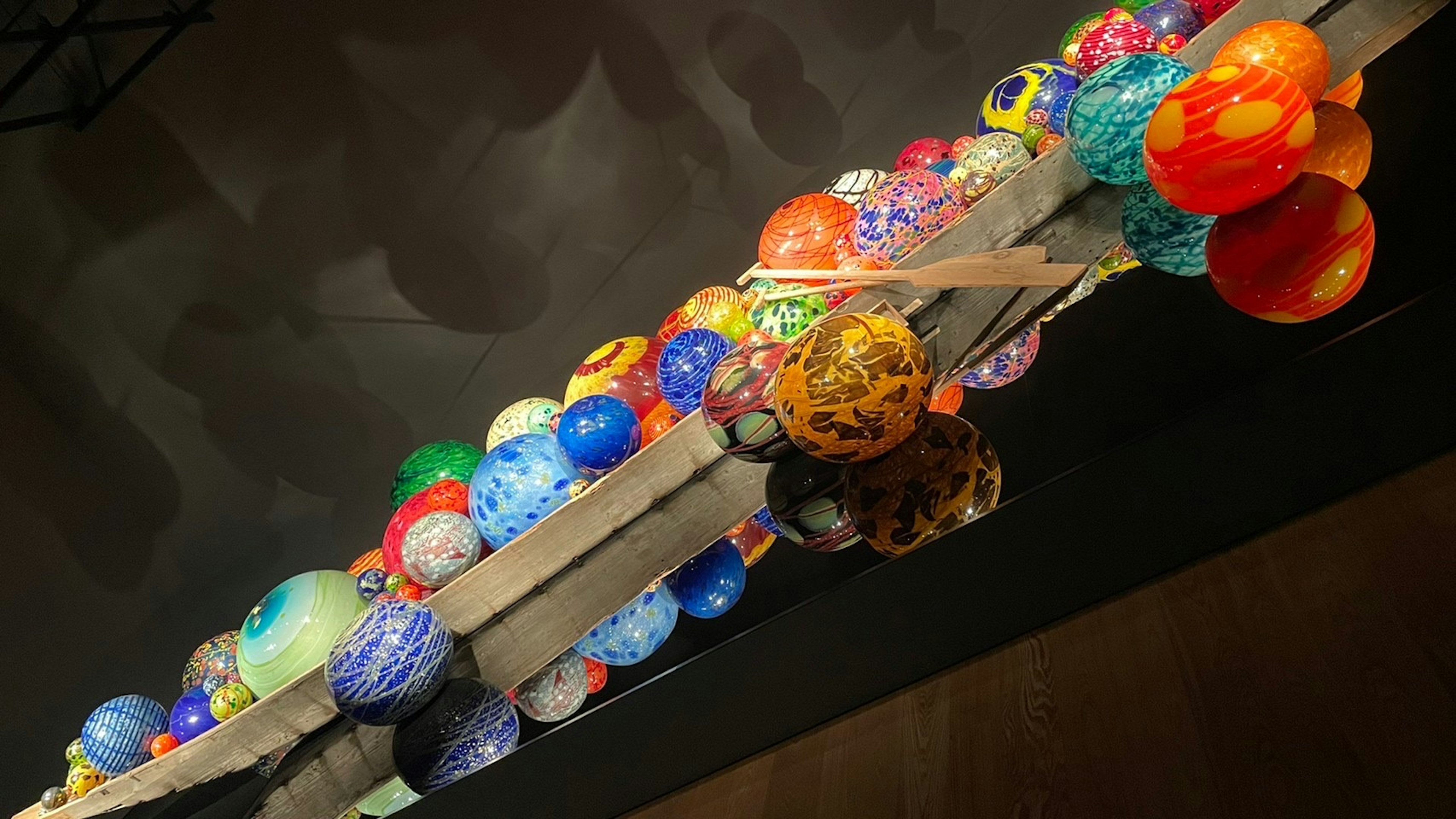 Colorful lanterns hanging on a wooden beam in an art installation