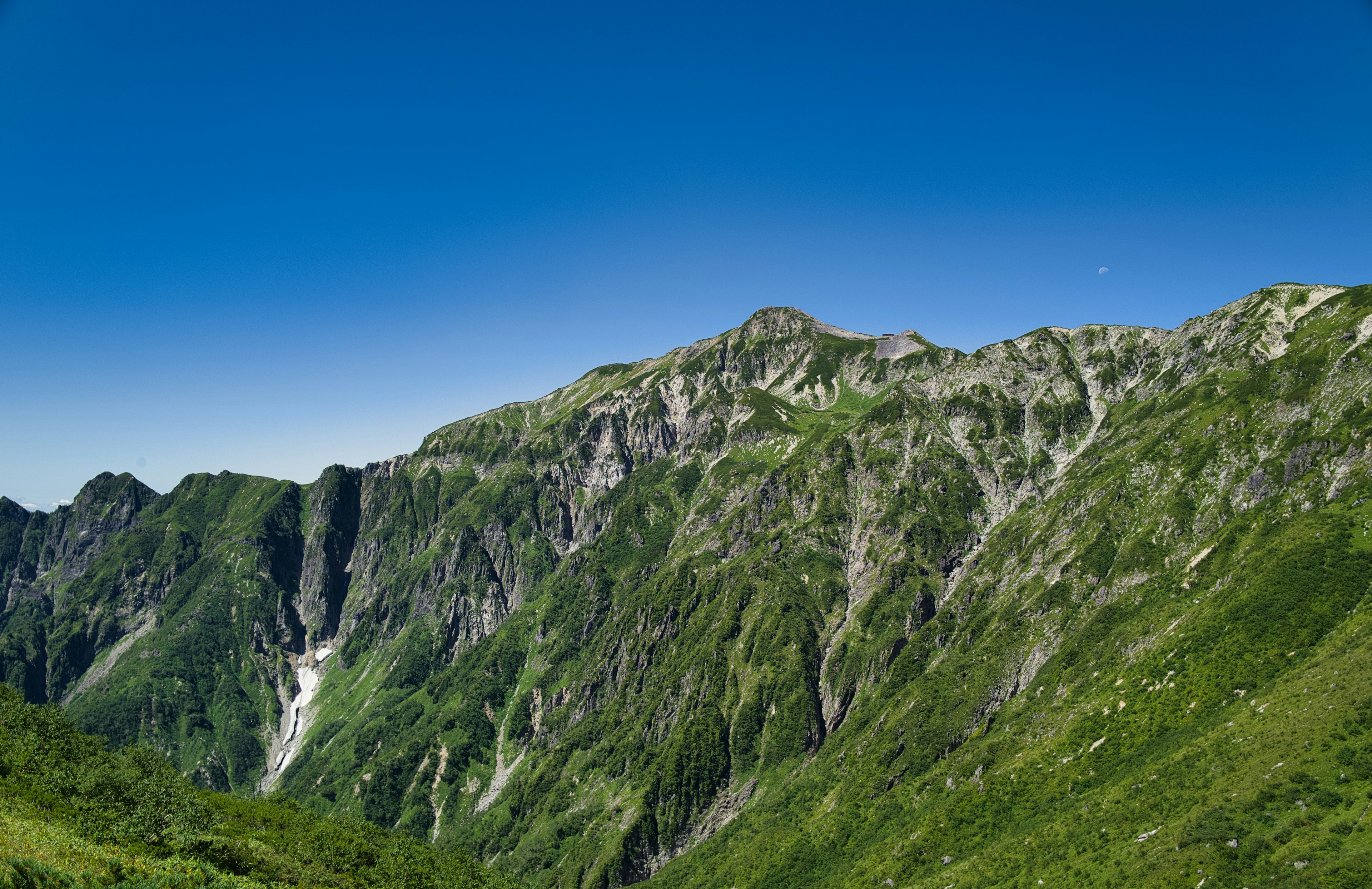 Lush green mountains under a clear blue sky