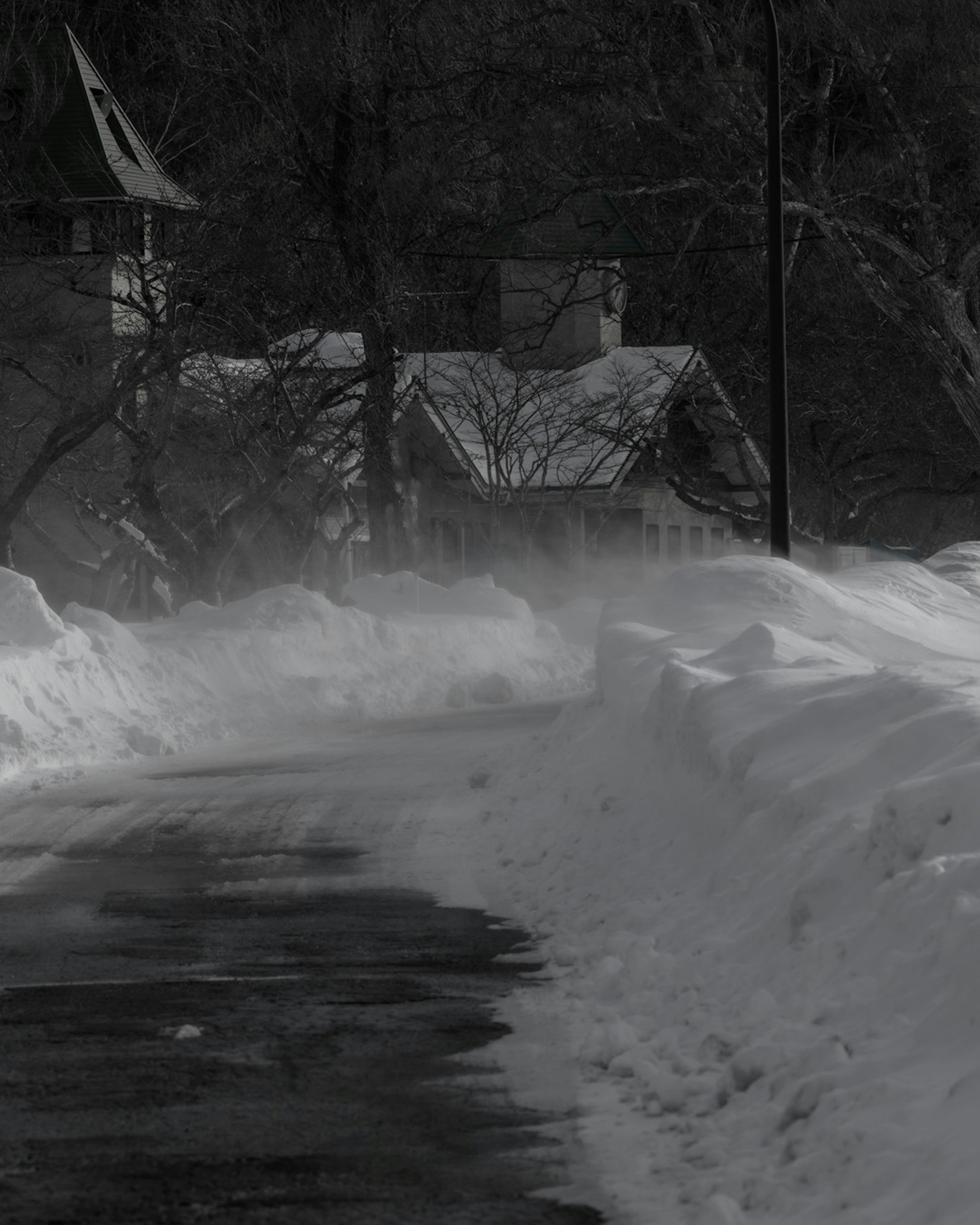 Route enneigée avec une maison dans un paysage d'hiver