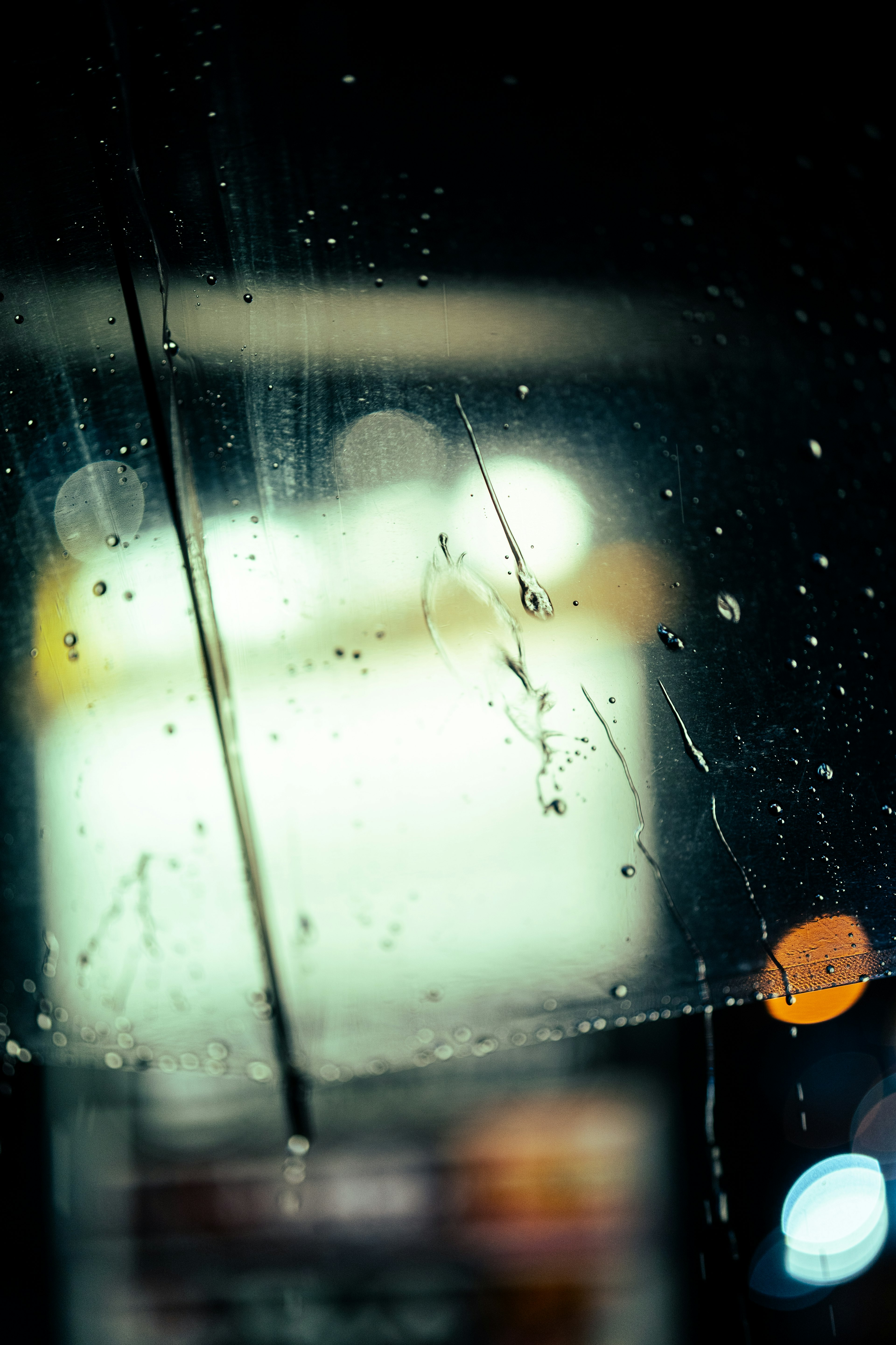 Verschwommene Sicht auf ein Schild durch ein regennasses Fenster