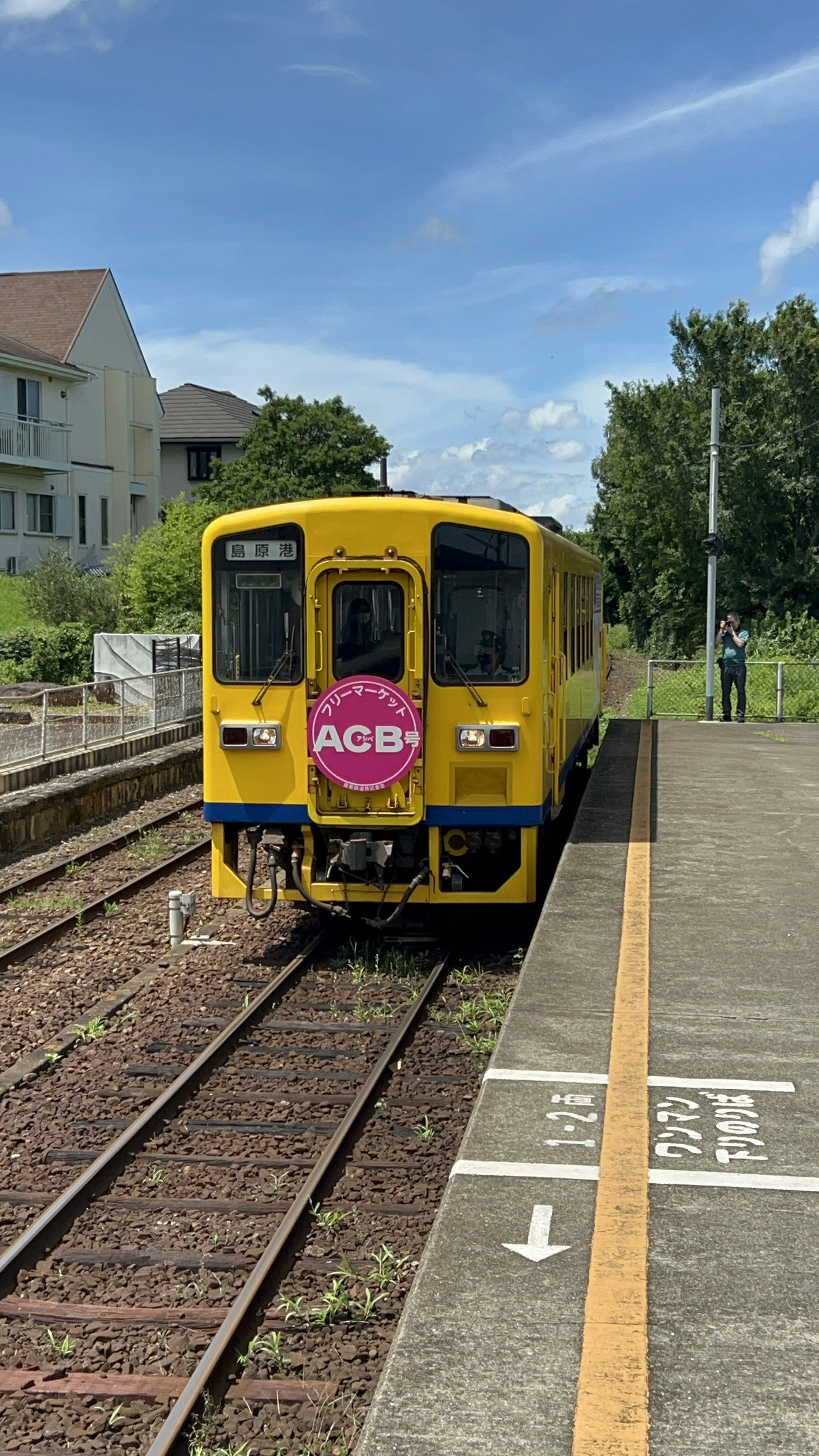 Tren amarillo detenido en una estación bajo un cielo despejado