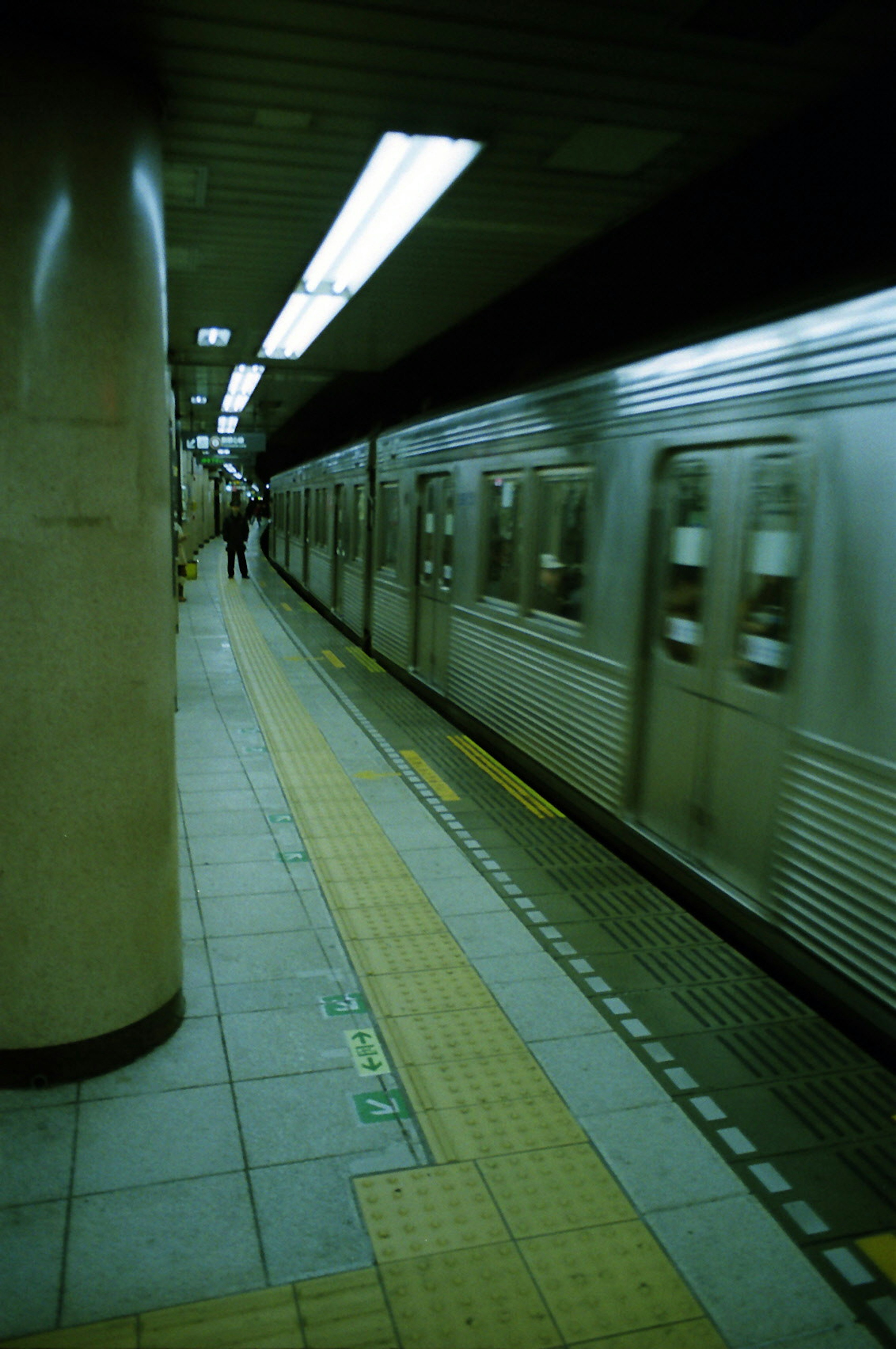 Subway platform with a train arriving and people waiting