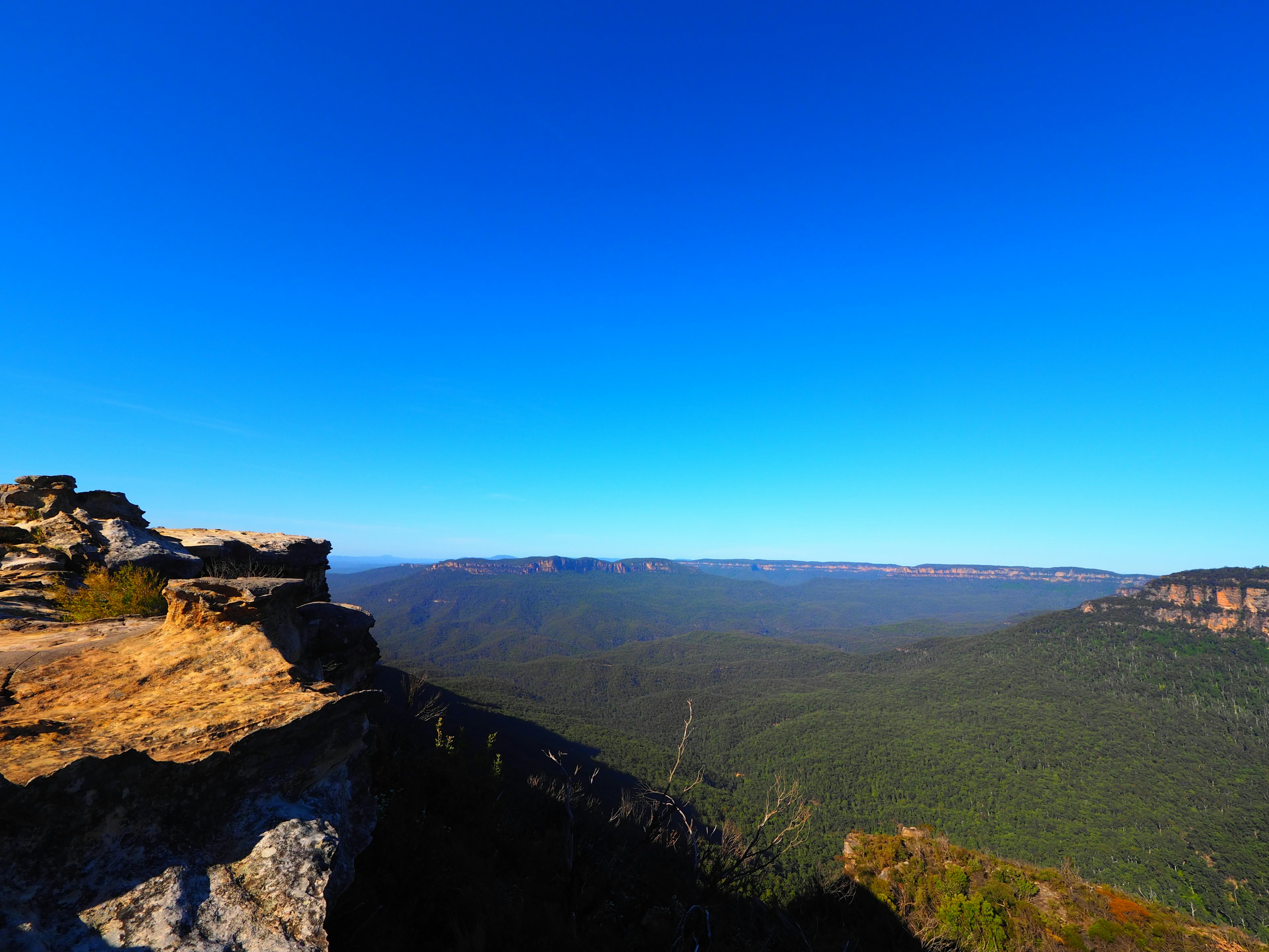 Vista panorámica de montañas verdes bajo un cielo azul claro