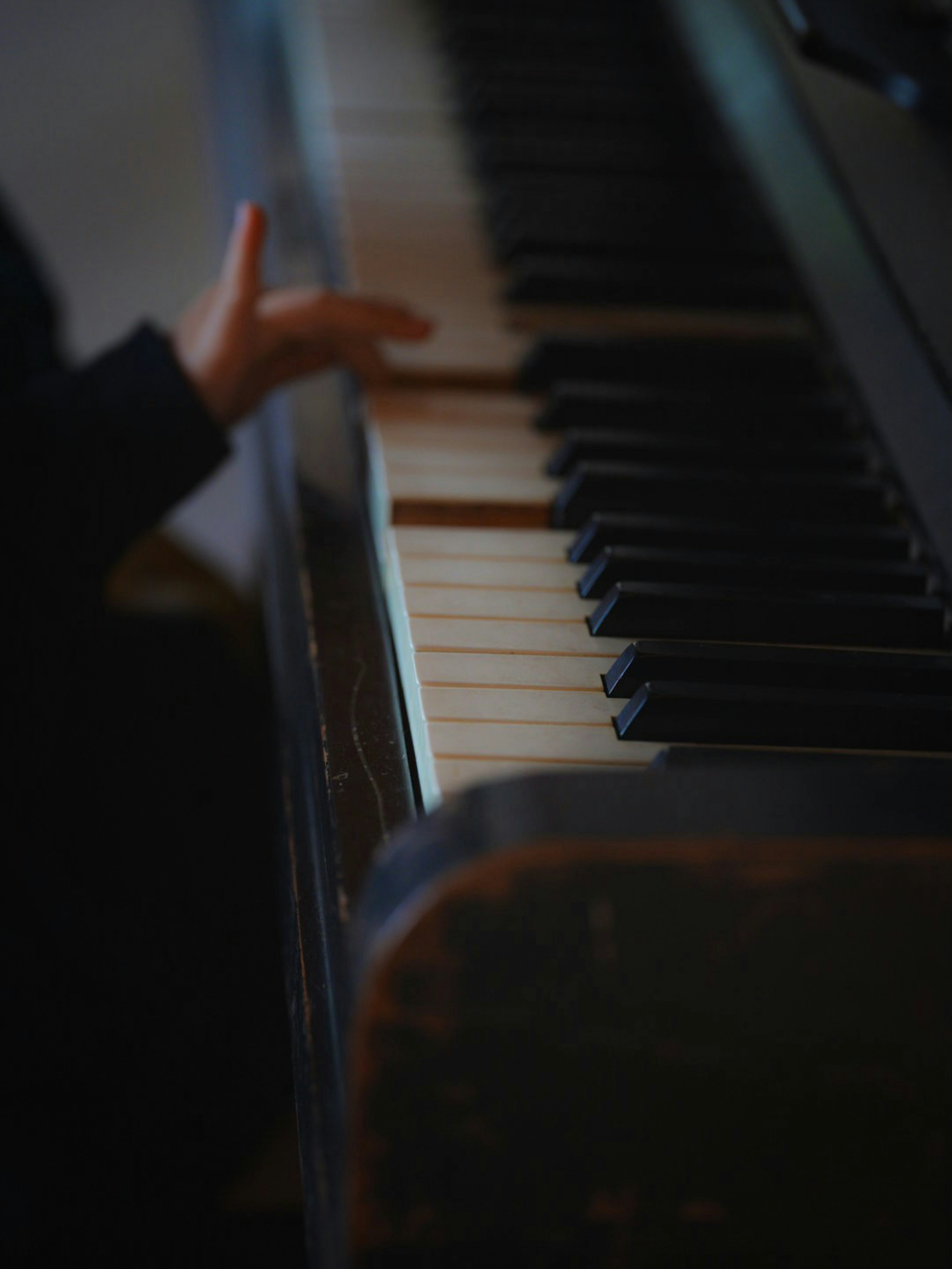 Primo piano di una mano che suona i tasti del pianoforte