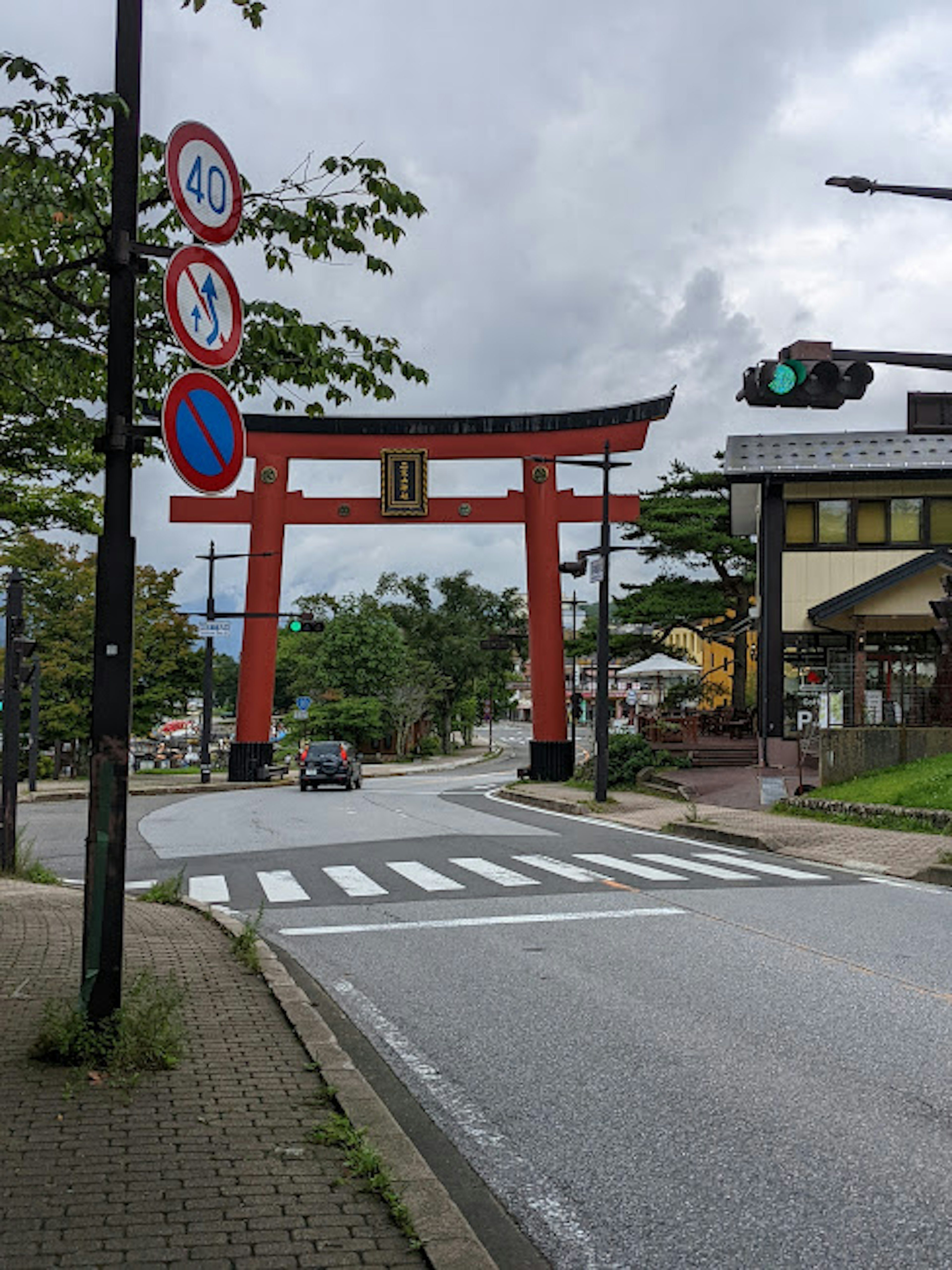 赤い鳥居と交通標識のある道路風景