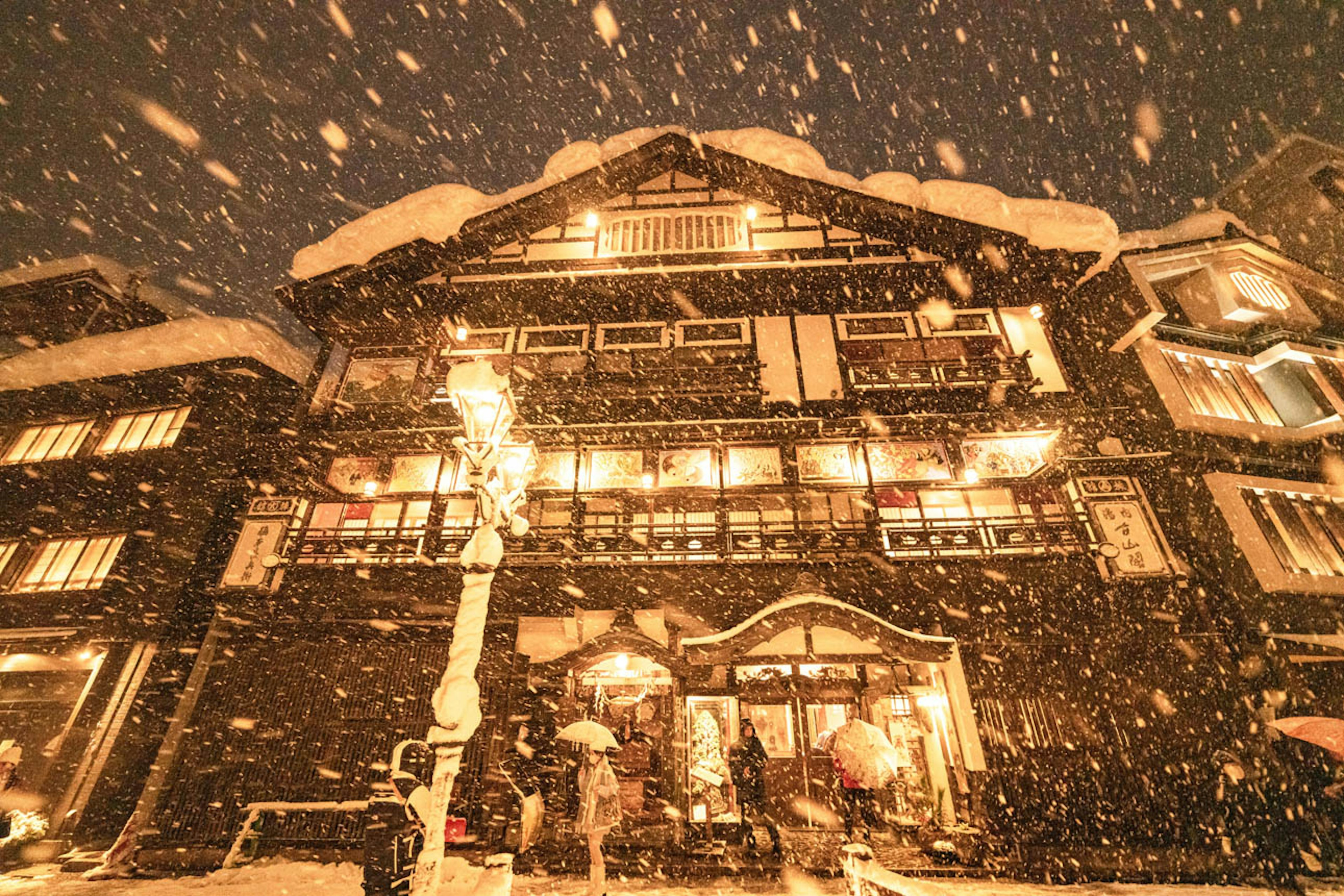 Bâtiment traditionnel illuminé par des lumières chaudes sous la neige