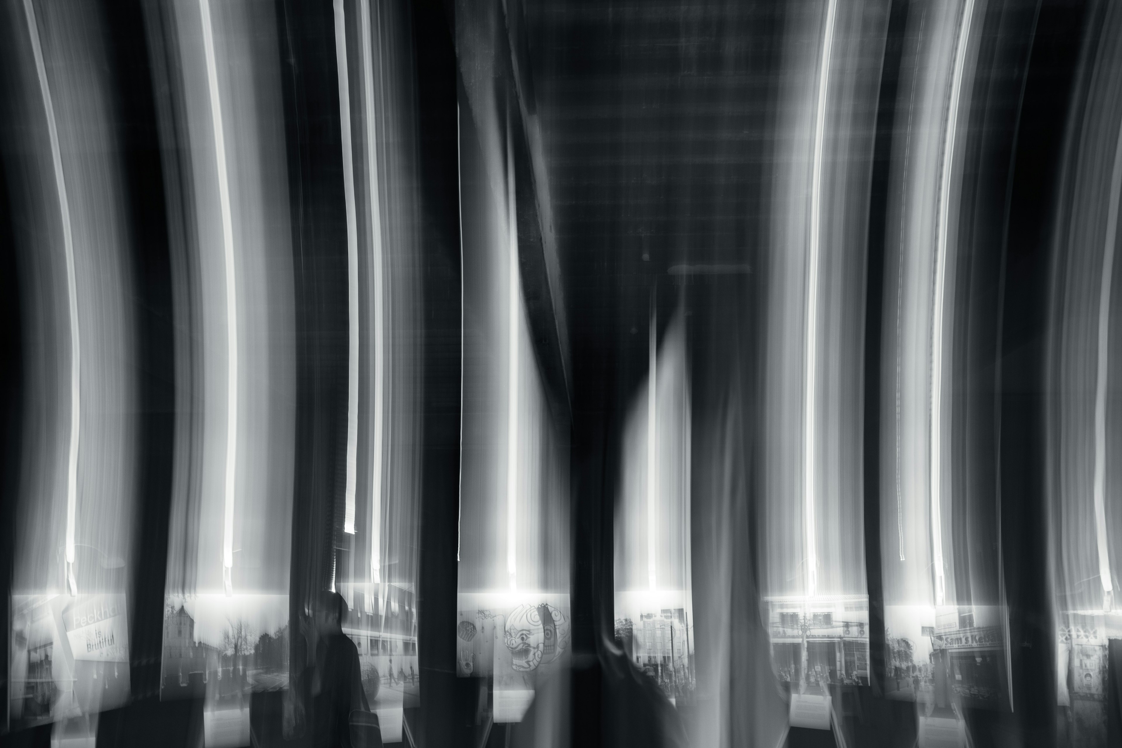 Abstract black and white image featuring striking curved light stripes