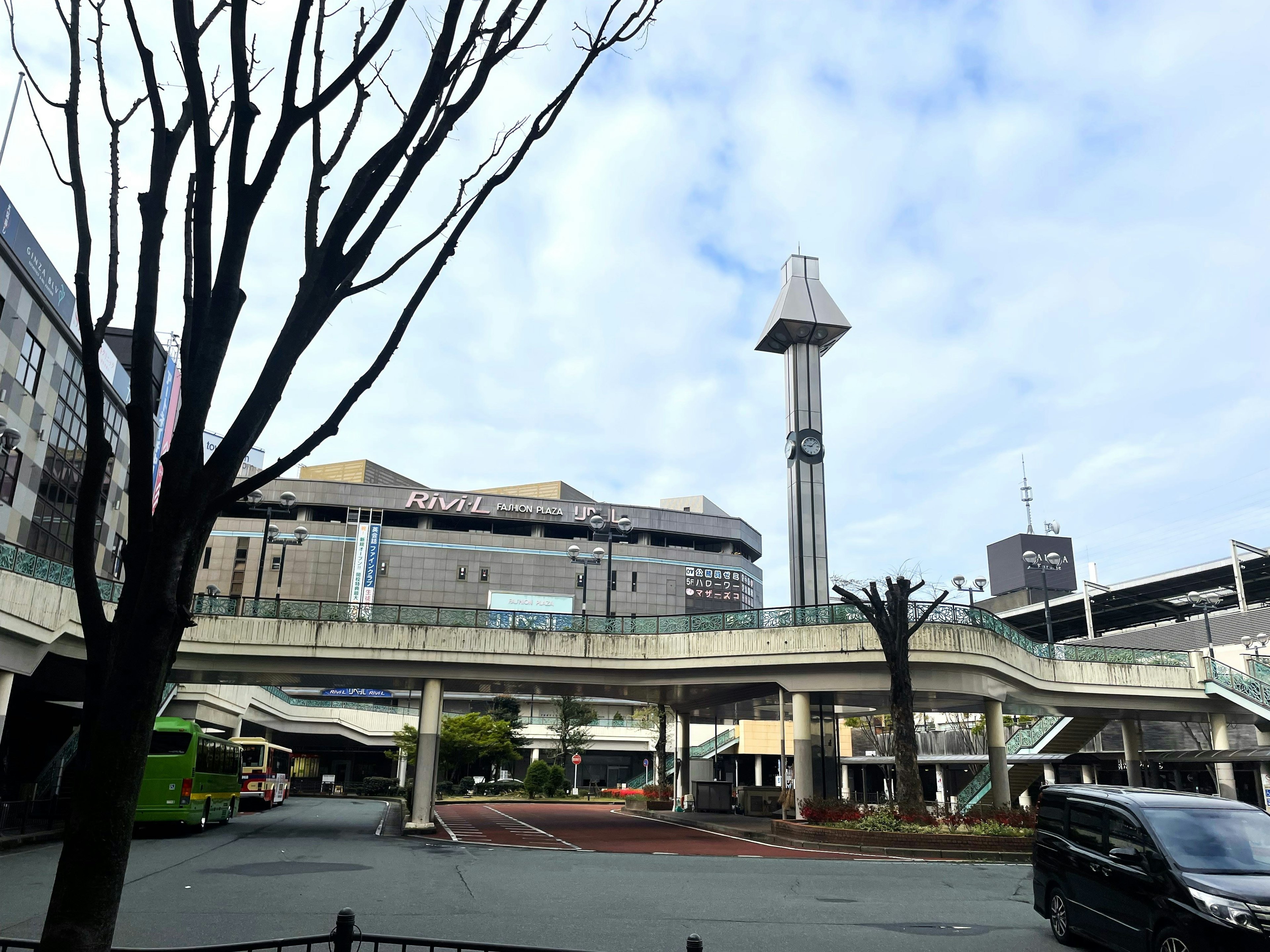 View of a plaza in front of a station with a clock tower