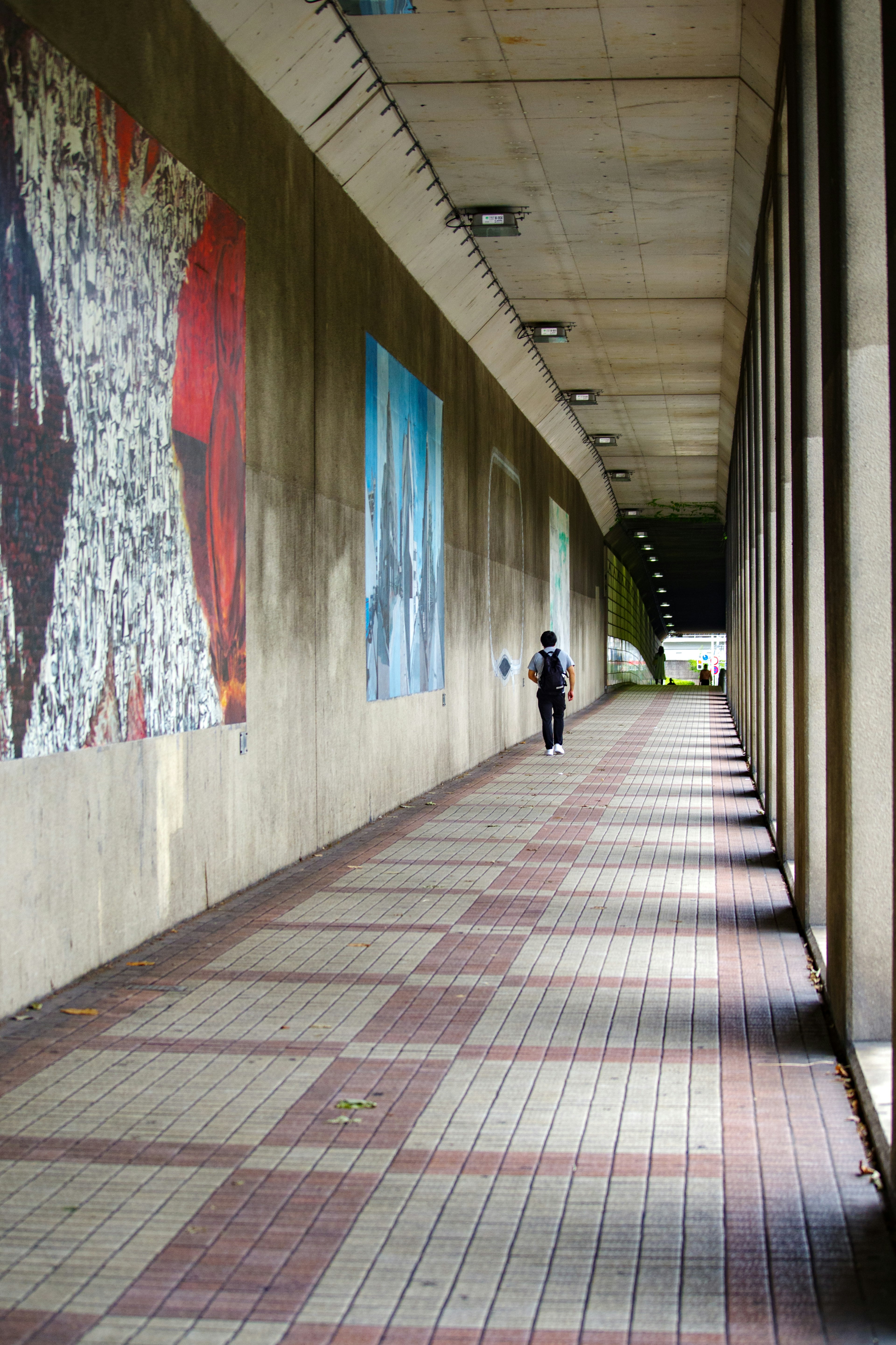 Largo pasillo con obras de arte coloridas en las paredes