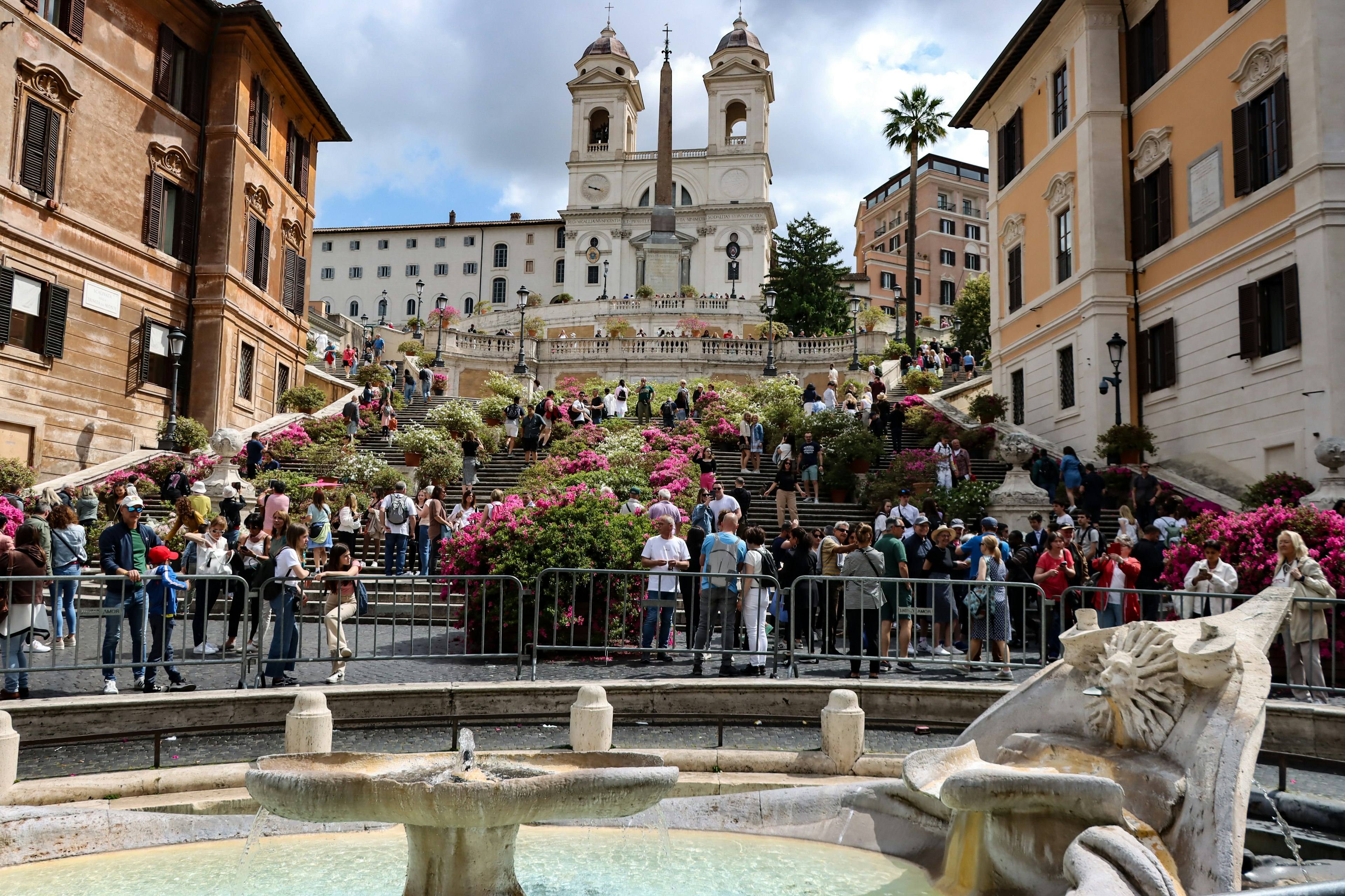 Vista de la Escalinata Española con flores en plena floración y multitudes de personas