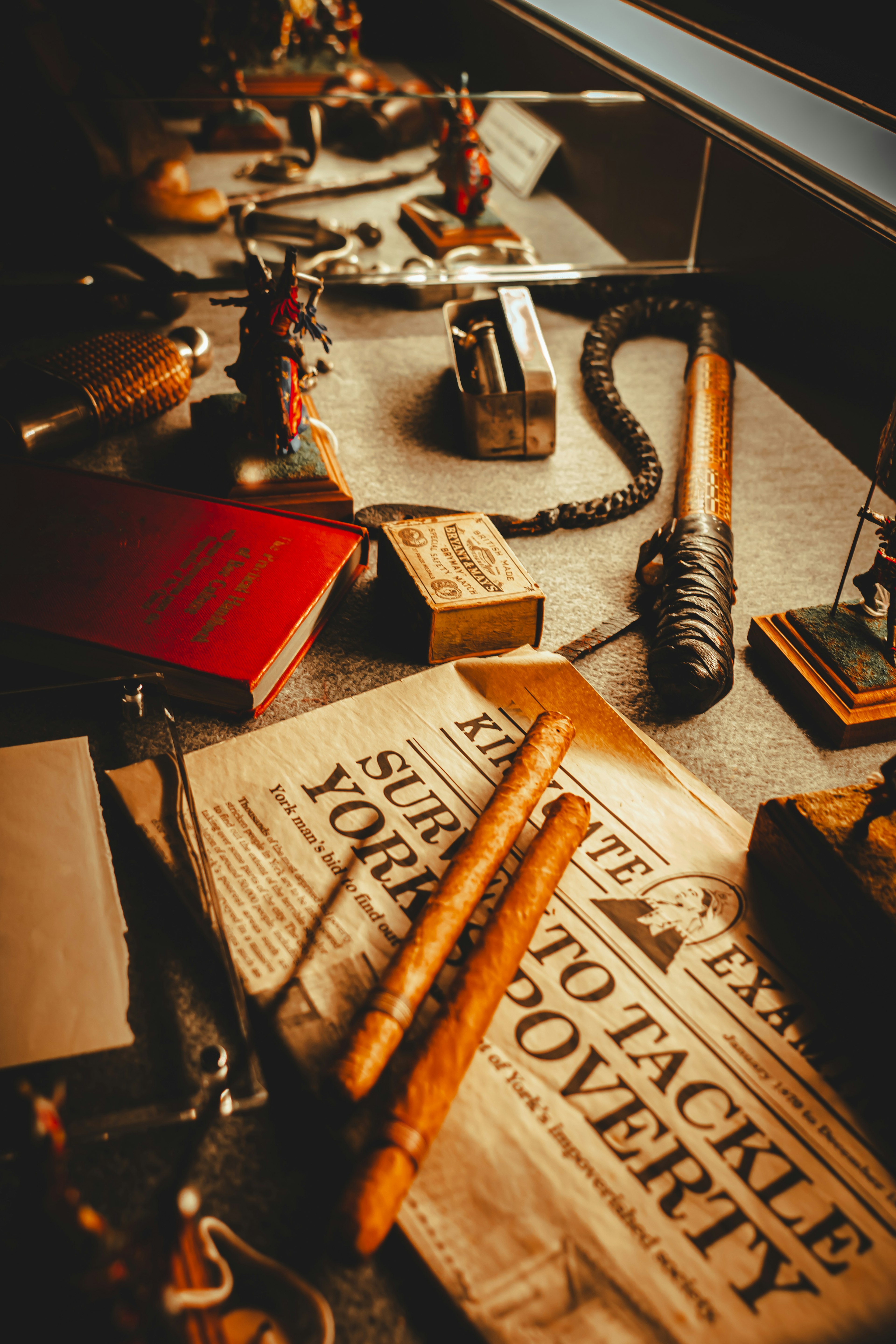 A collection of diverse objects on a table including old newspaper and various tools