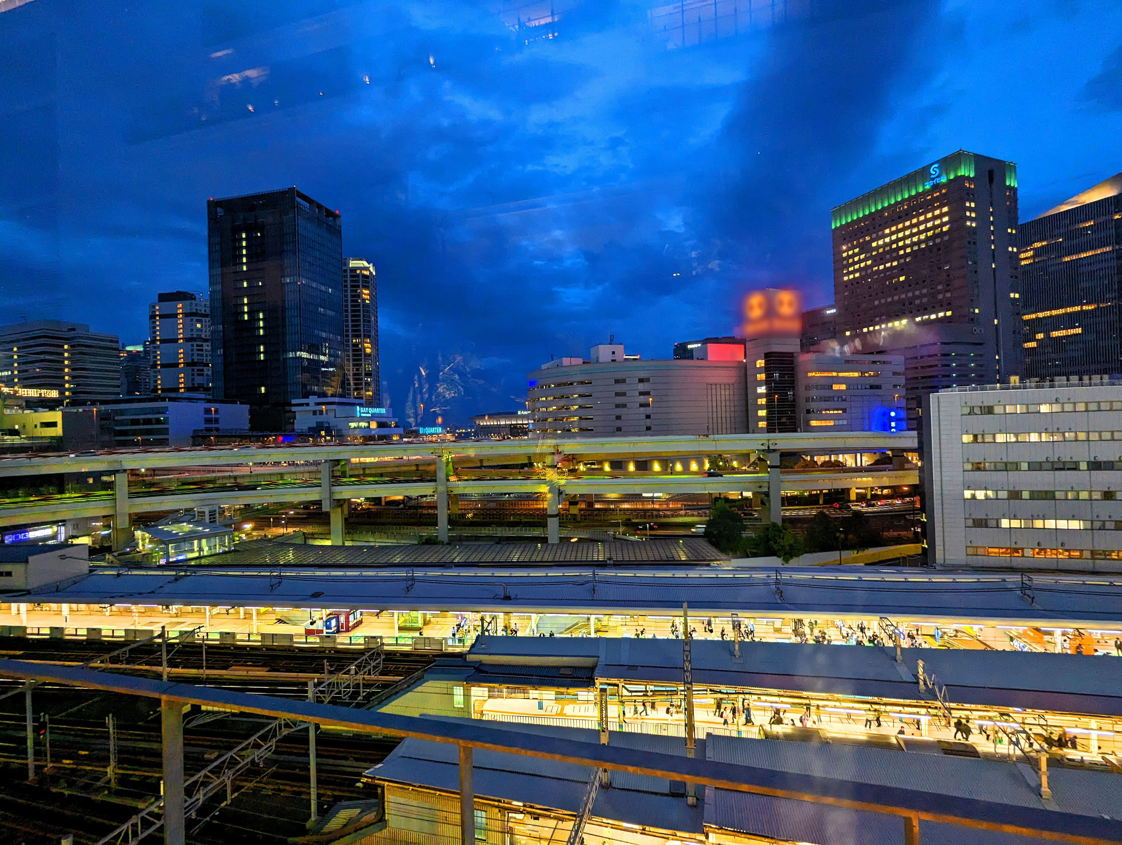 Night cityscape with skyscrapers and visible train station roof