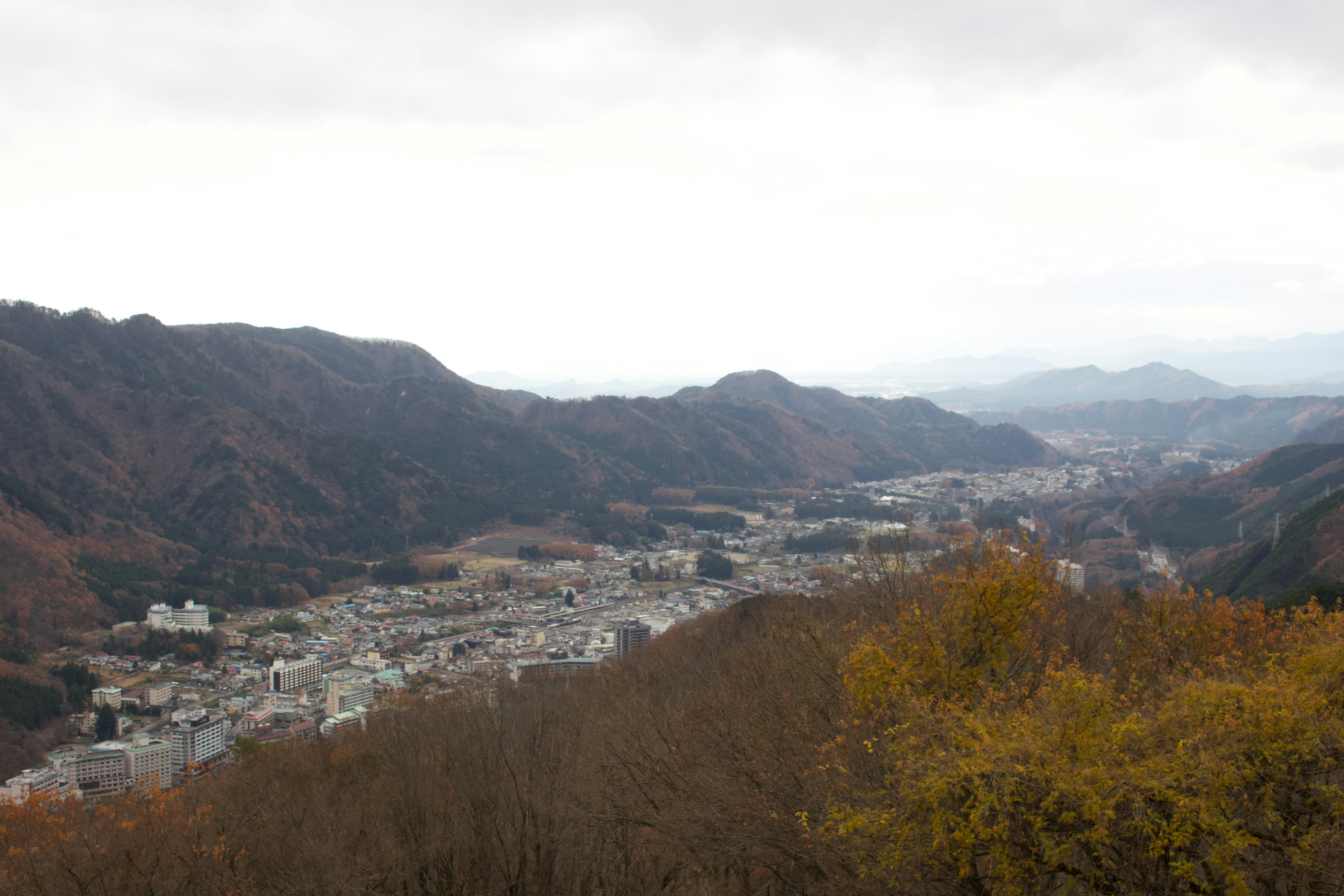 山々に囲まれた町の風景と曇り空