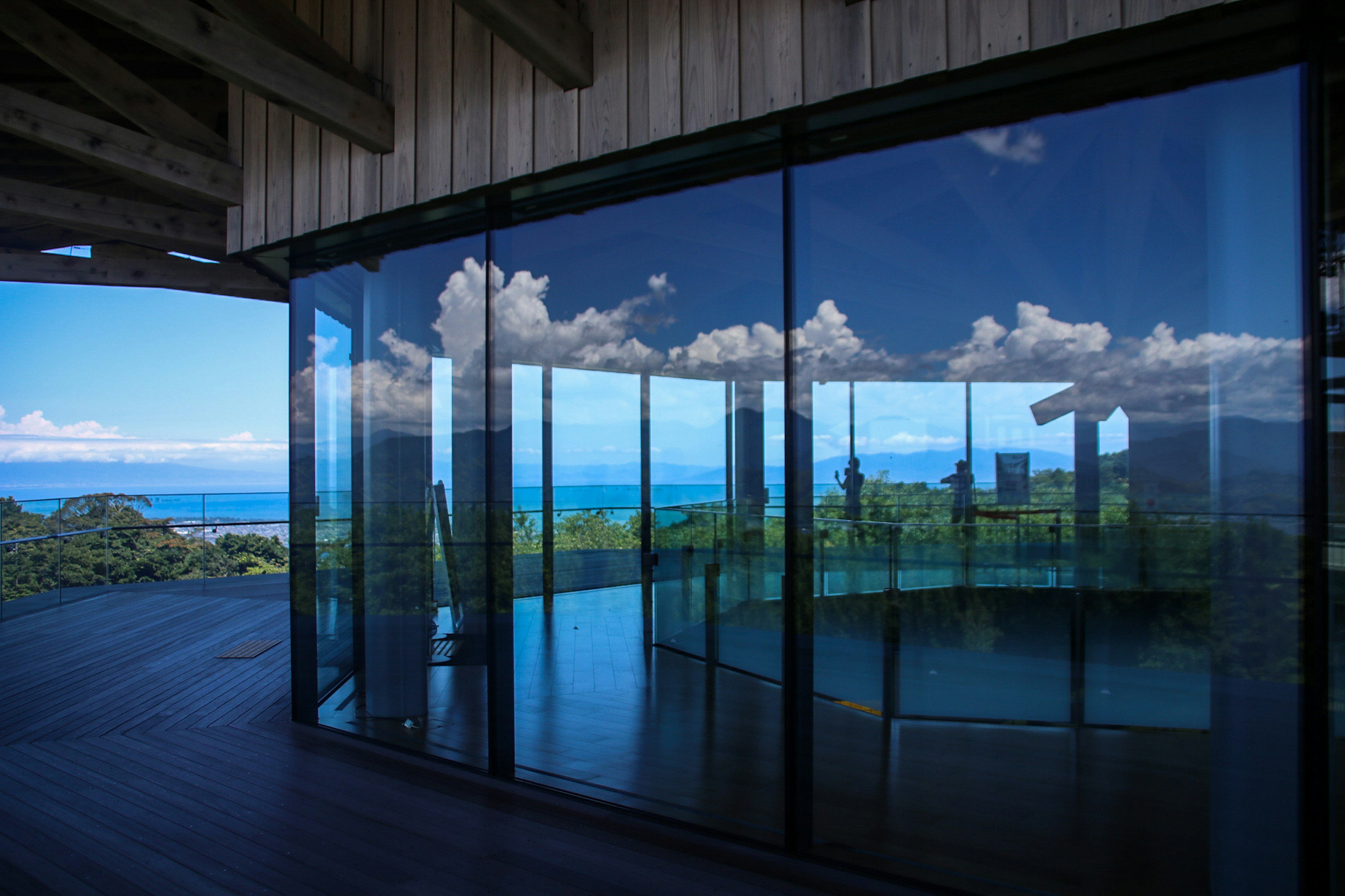 Modern interior with glass walls reflecting a beautiful ocean view