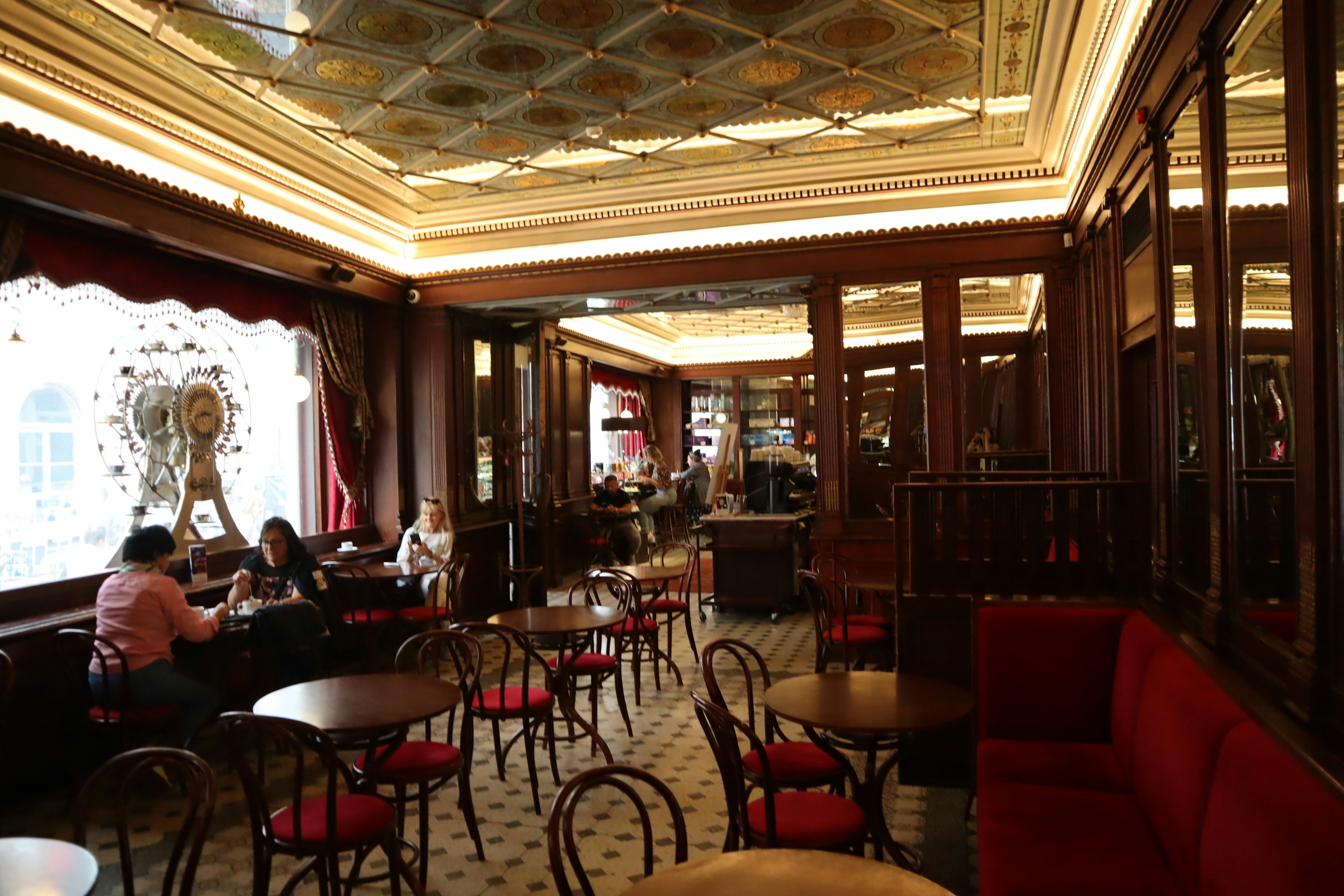 Elegant interior of a café featuring wooden furniture and red sofas