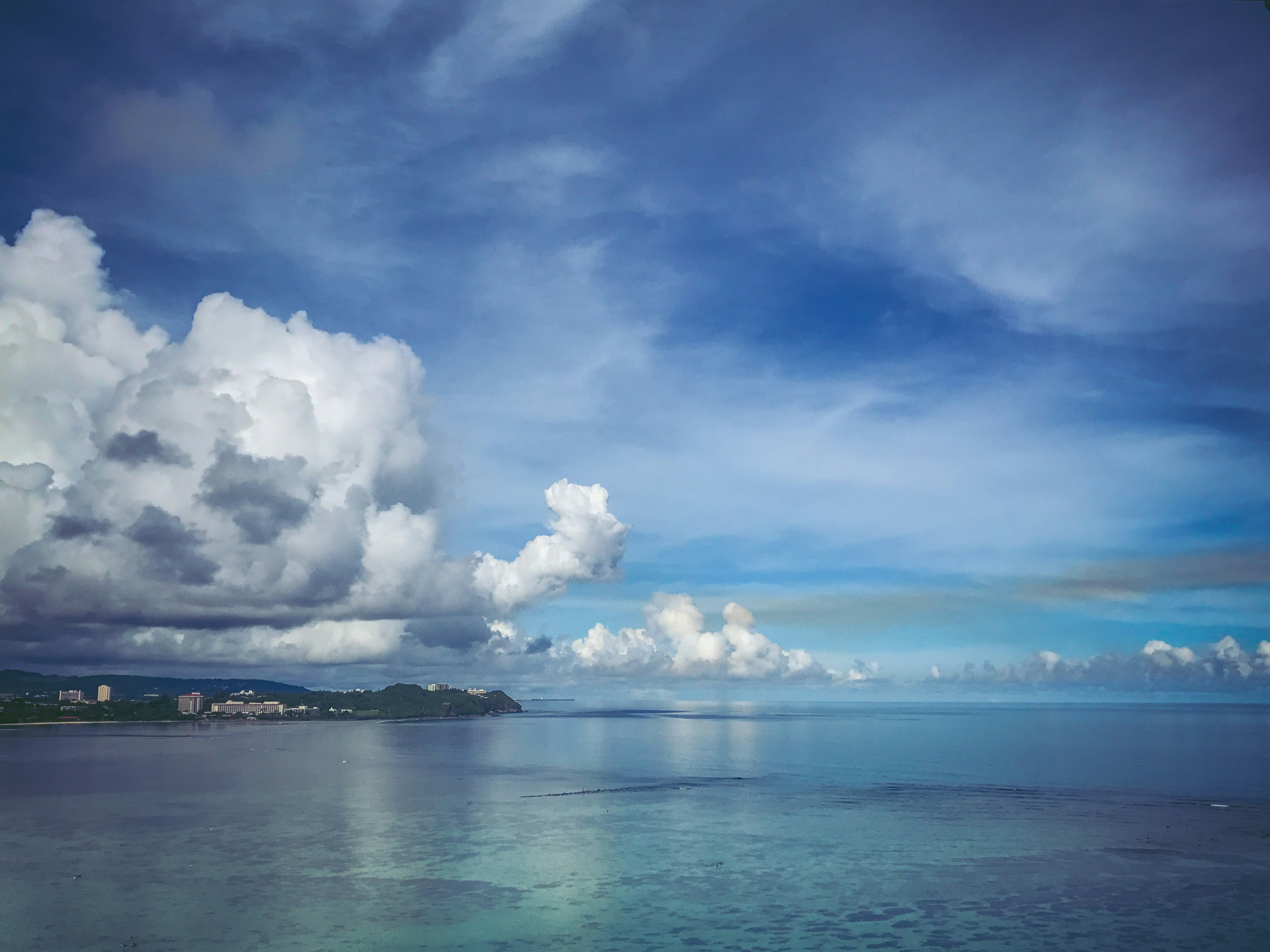 Scenic view of blue ocean and cloud-filled sky