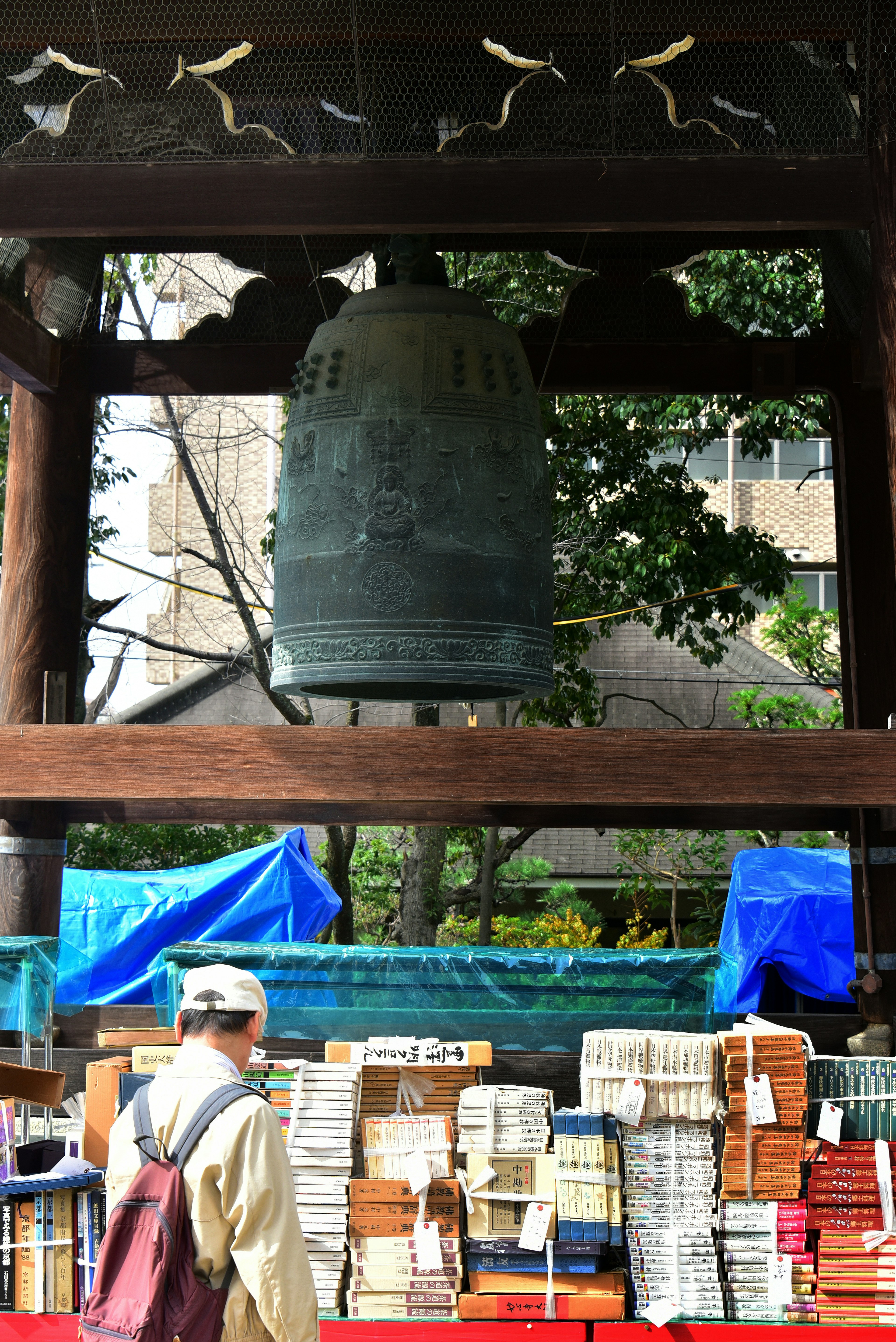 Une grande cloche en bronze avec des piles de livres devant