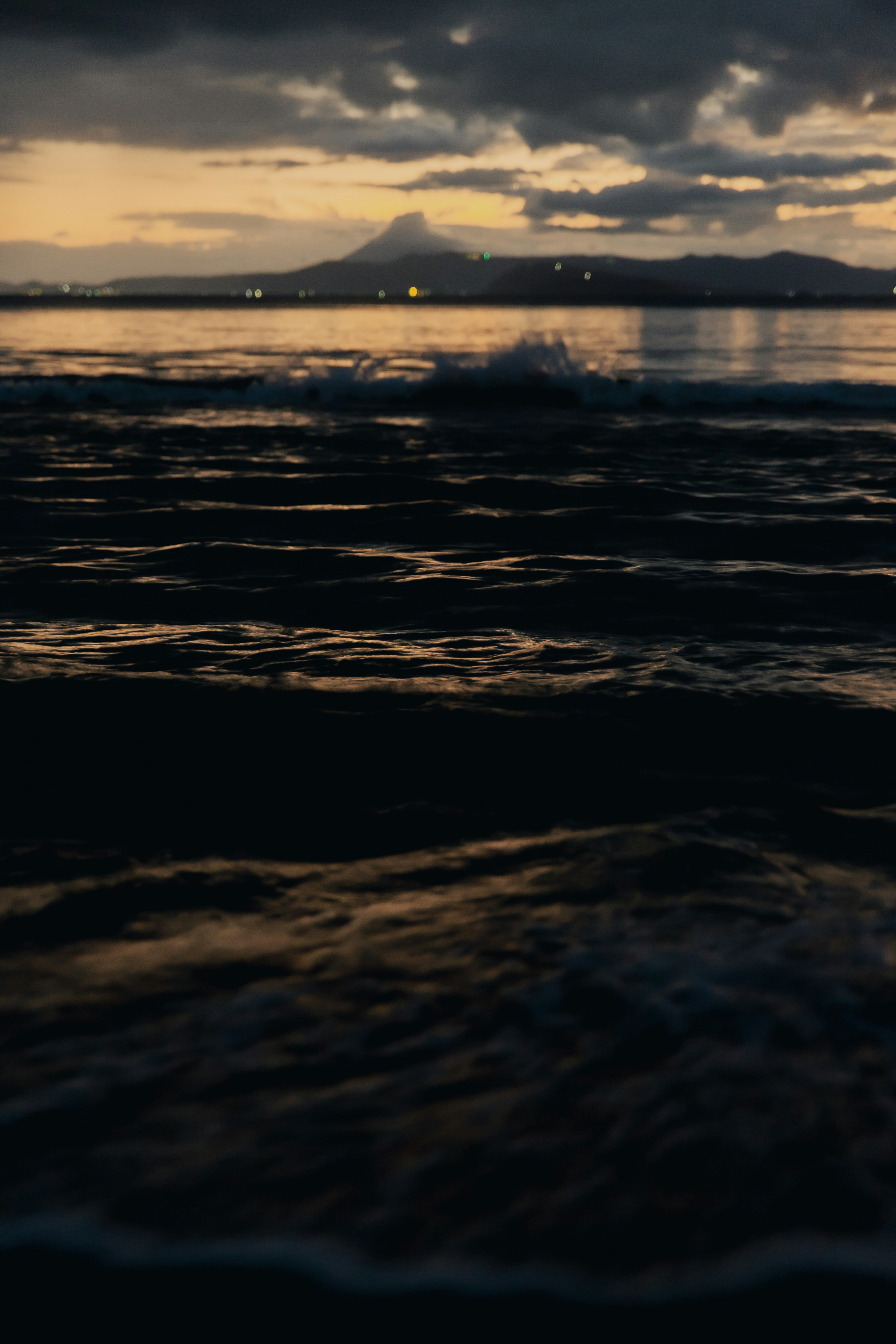 Serene ocean view at dusk with mountain silhouette