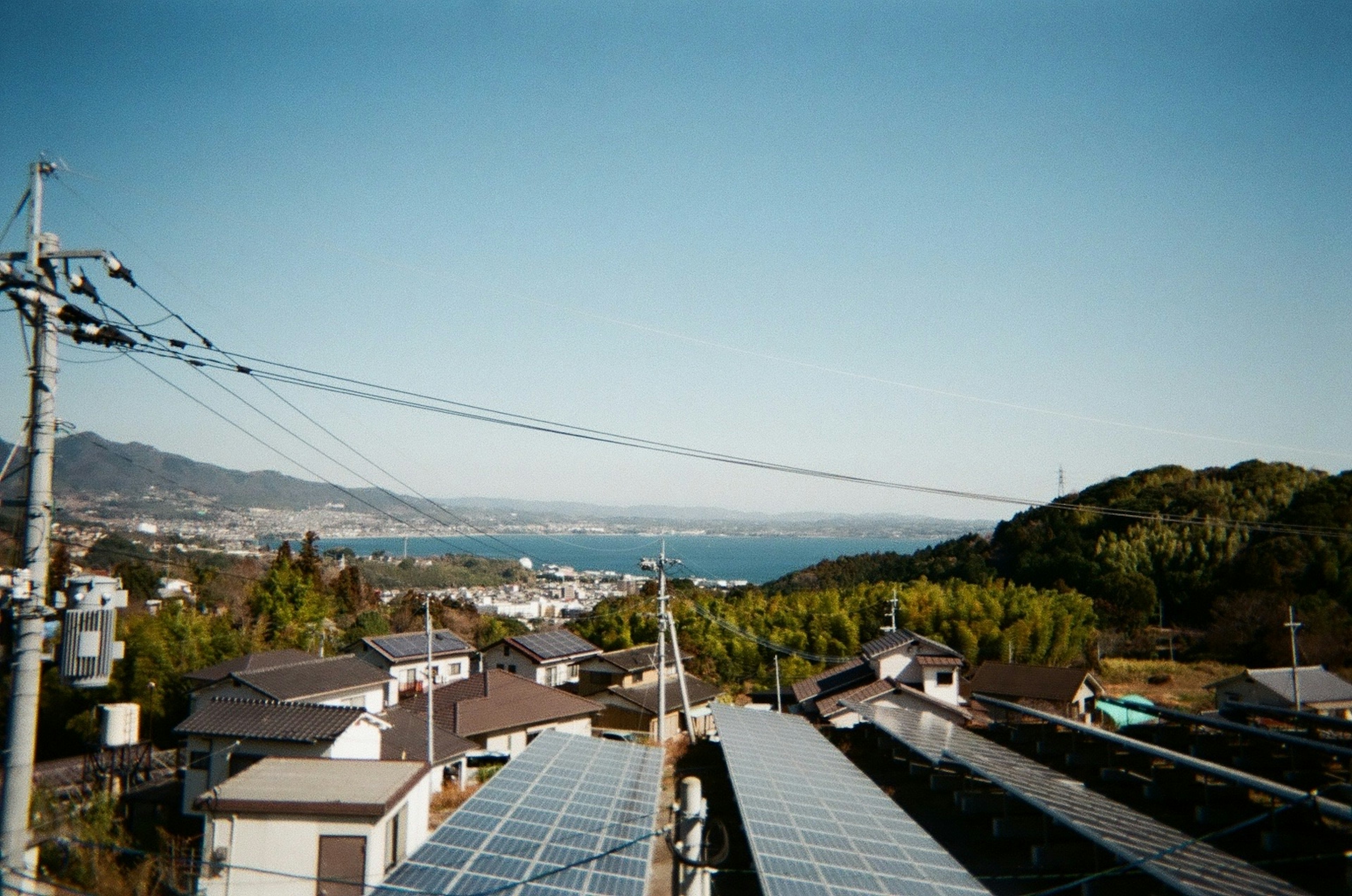 海と山の風景を背景にした屋根の上の太陽光パネル