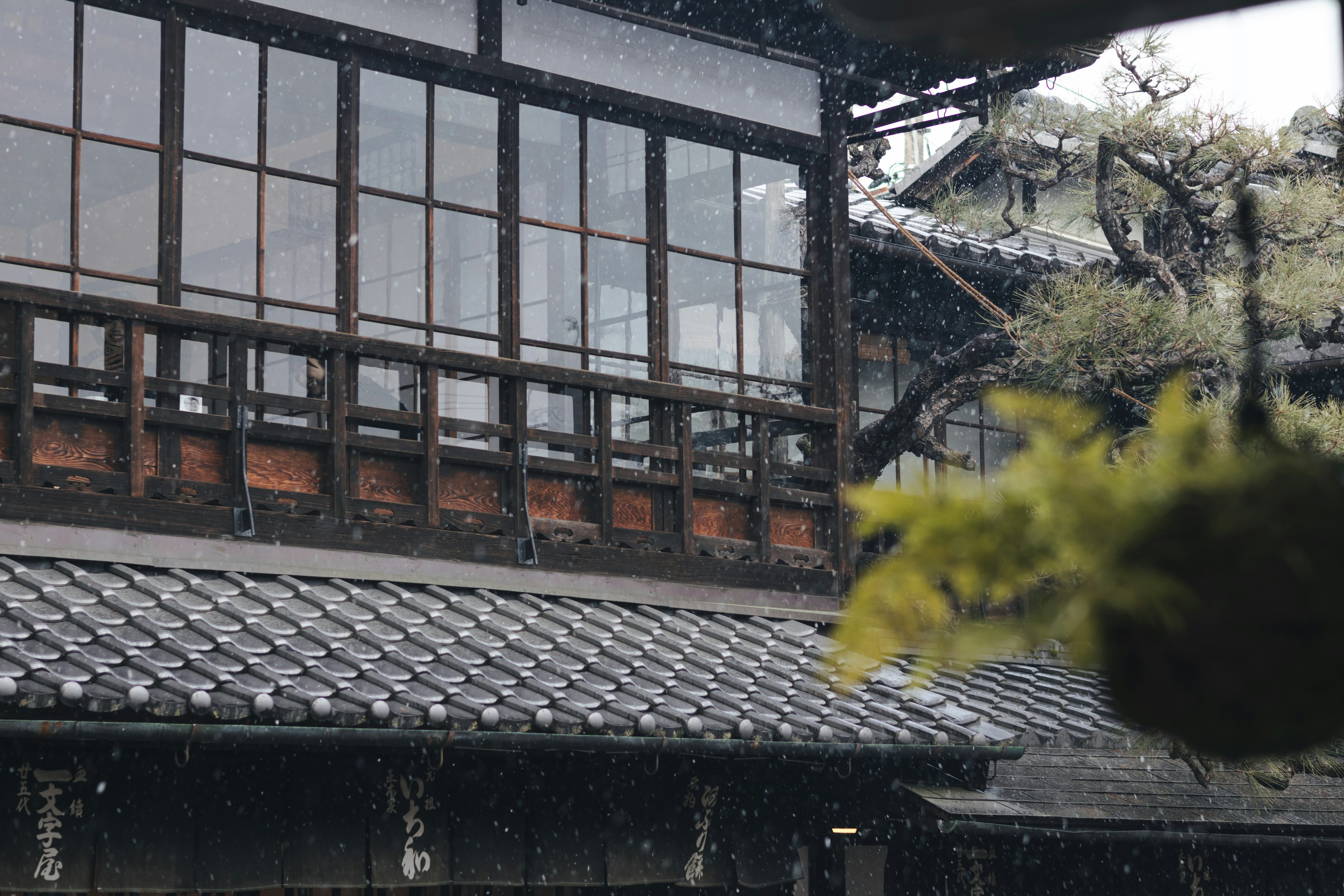 Traditional Japanese house with windows and roof in the rain