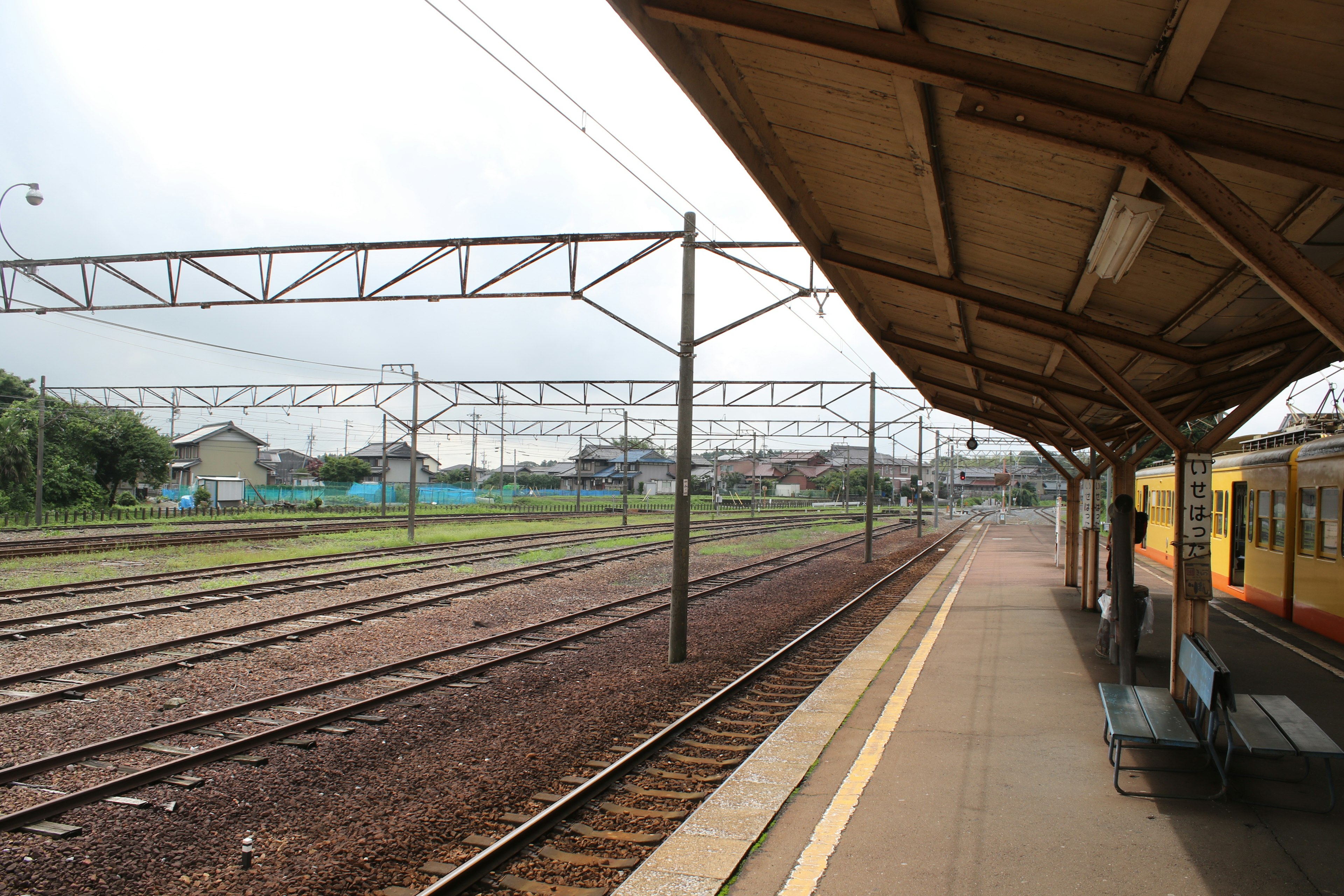 Quiet train station platform with visible railway tracks