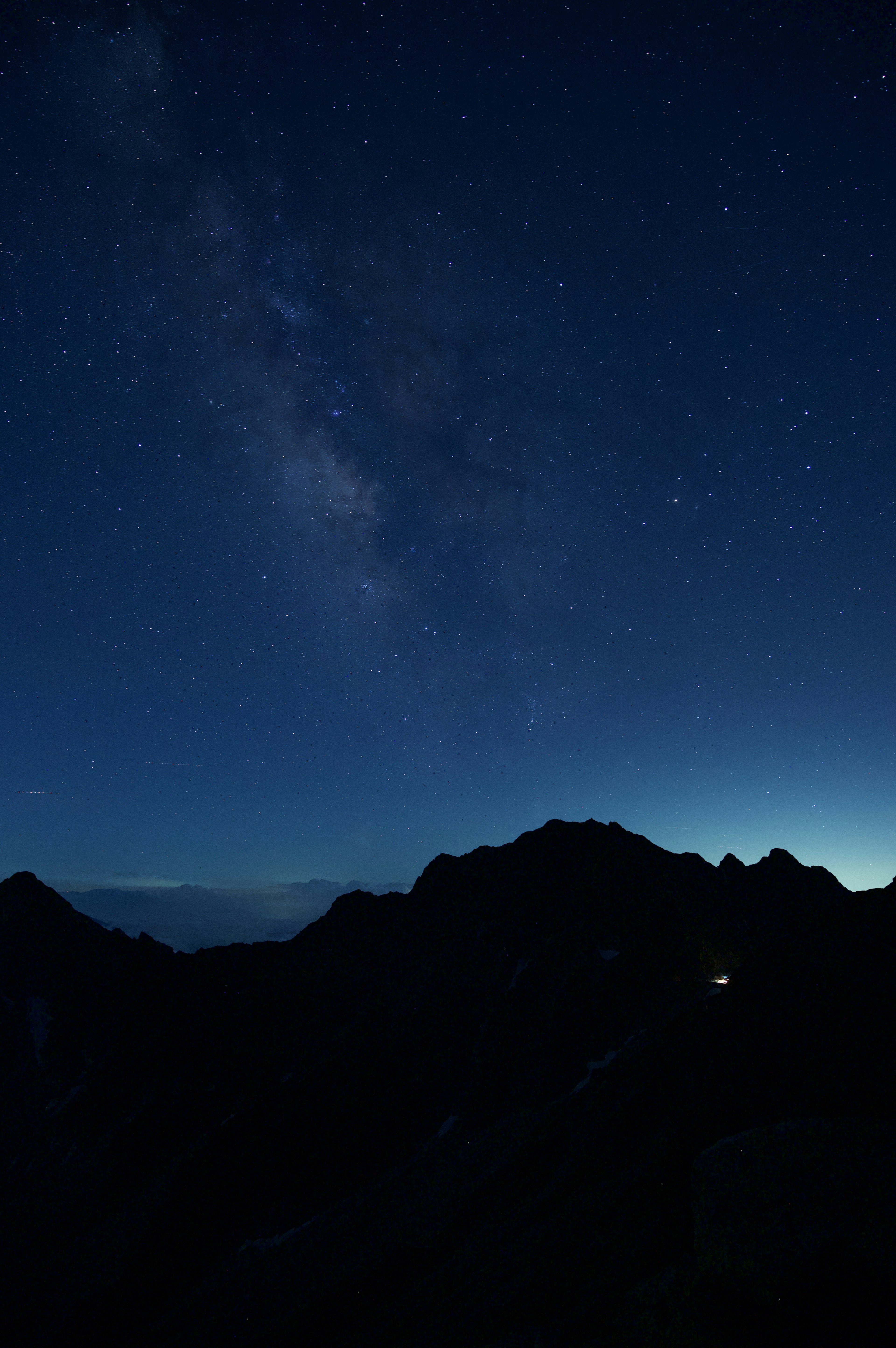 Gunung di bawah langit berbintang dengan fajar biru