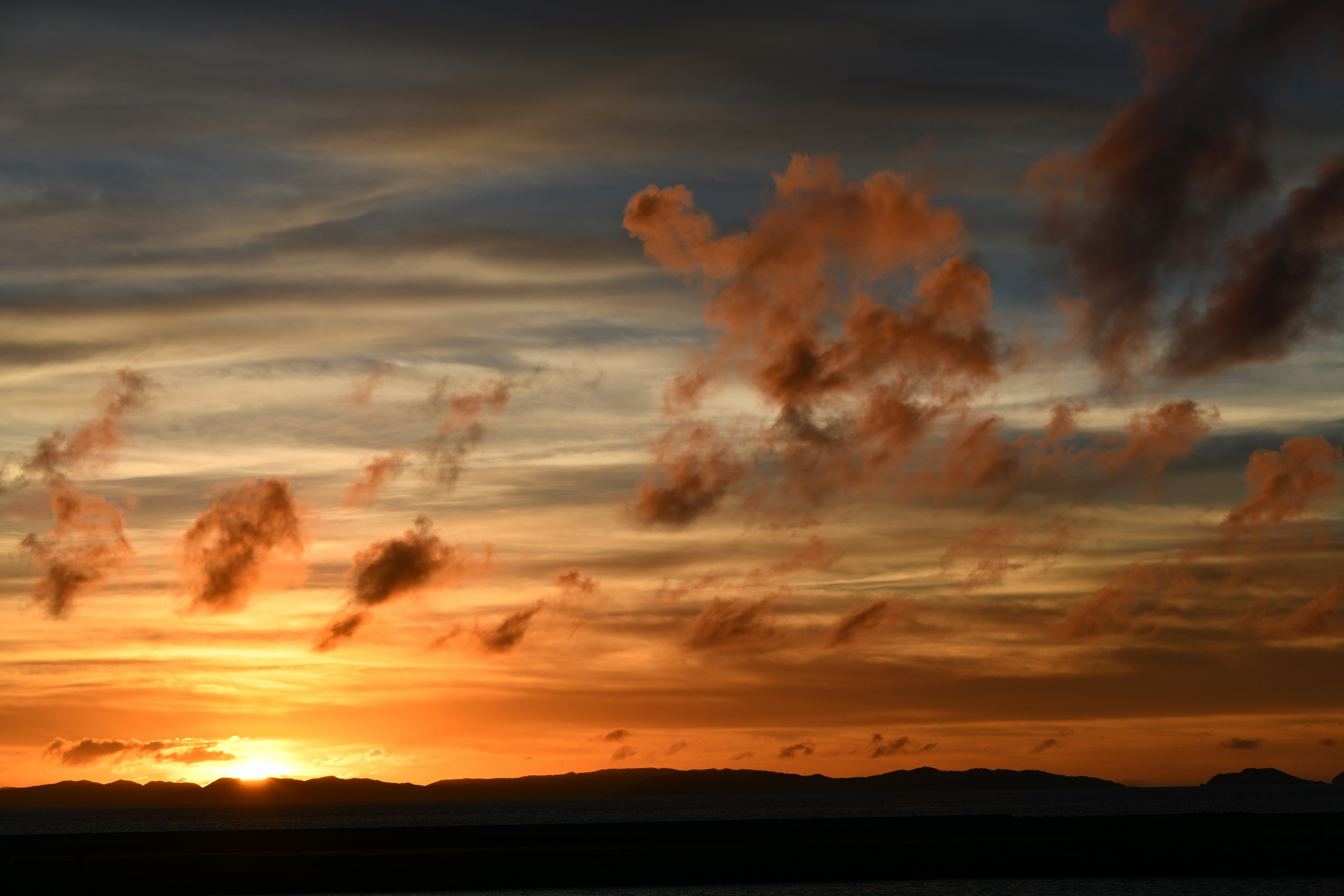 Impresionante vista del atardecer con nubes naranjas y moradas