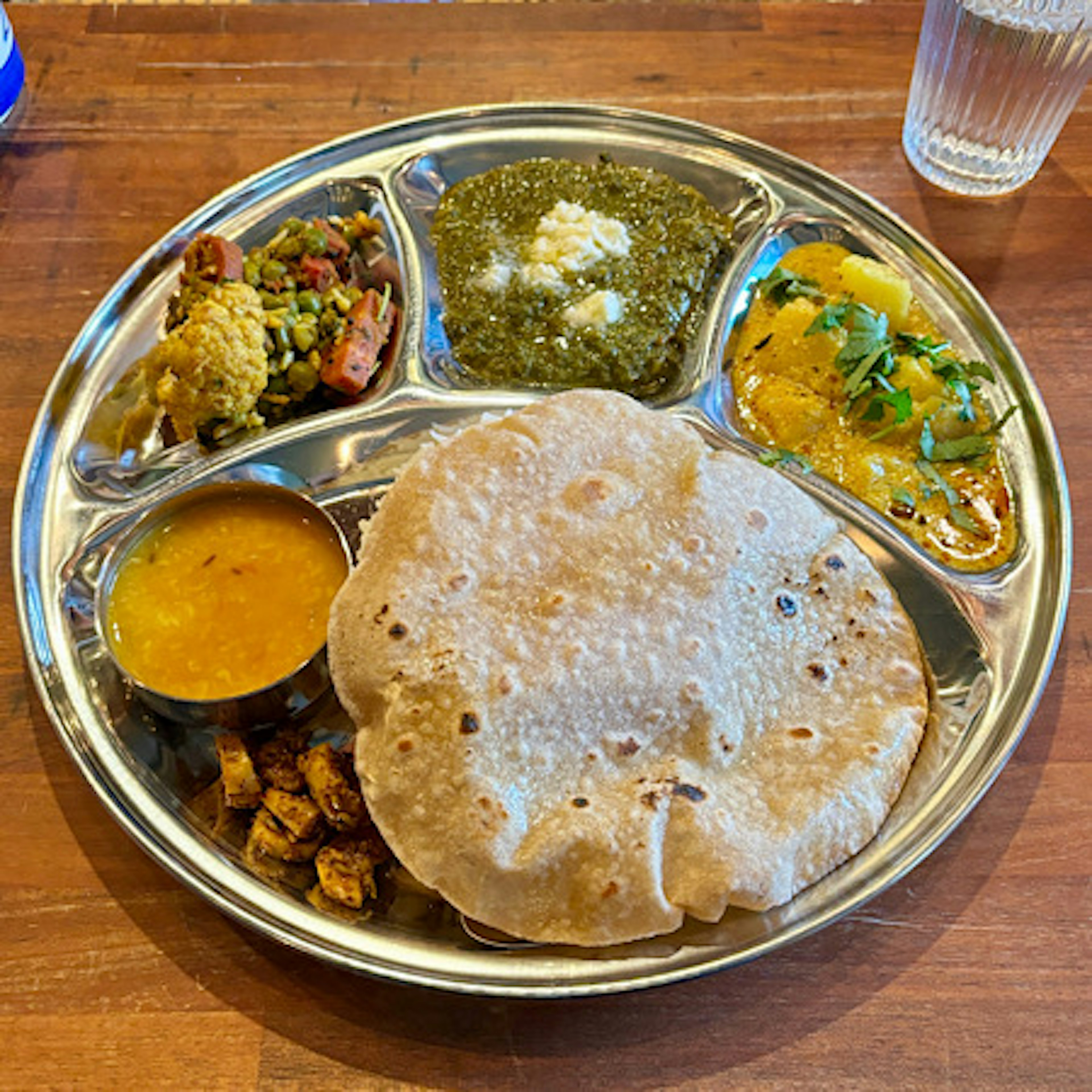 Thali India dengan roti, dal, sabzi, paneer, dan nasi