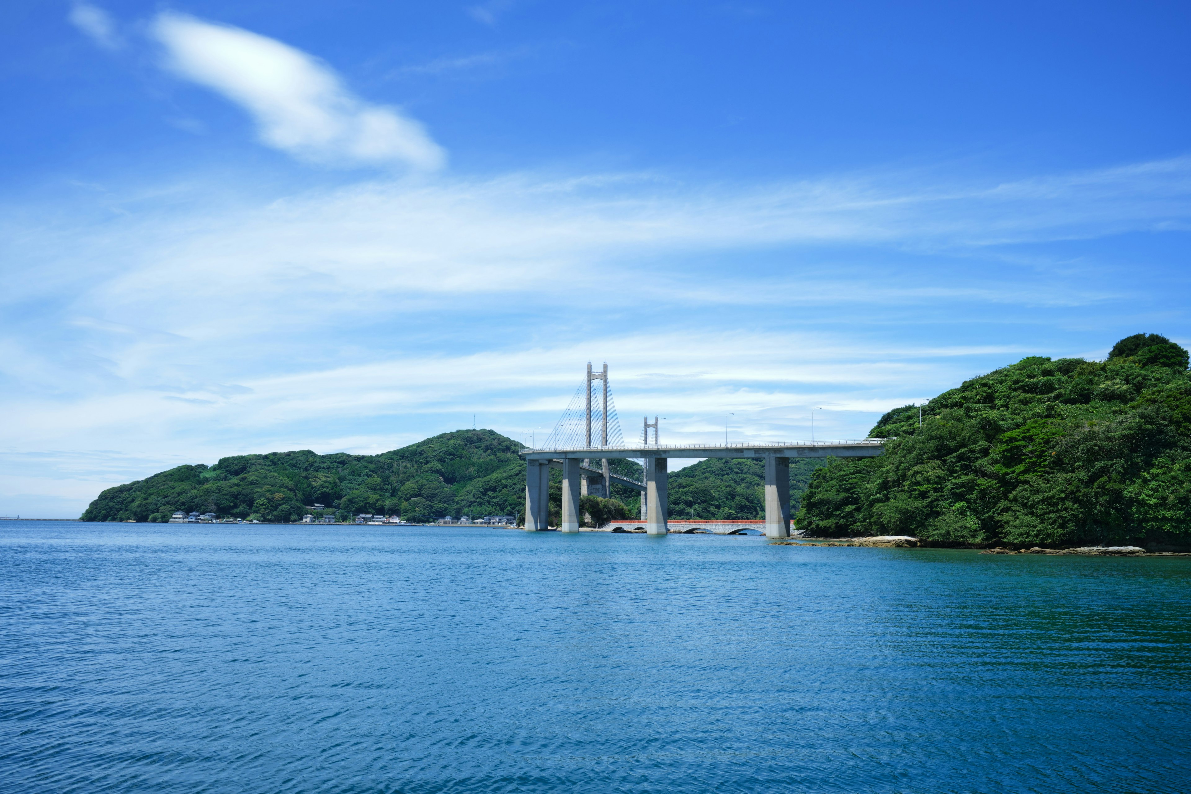 青い海と空の下にある橋と緑の島々