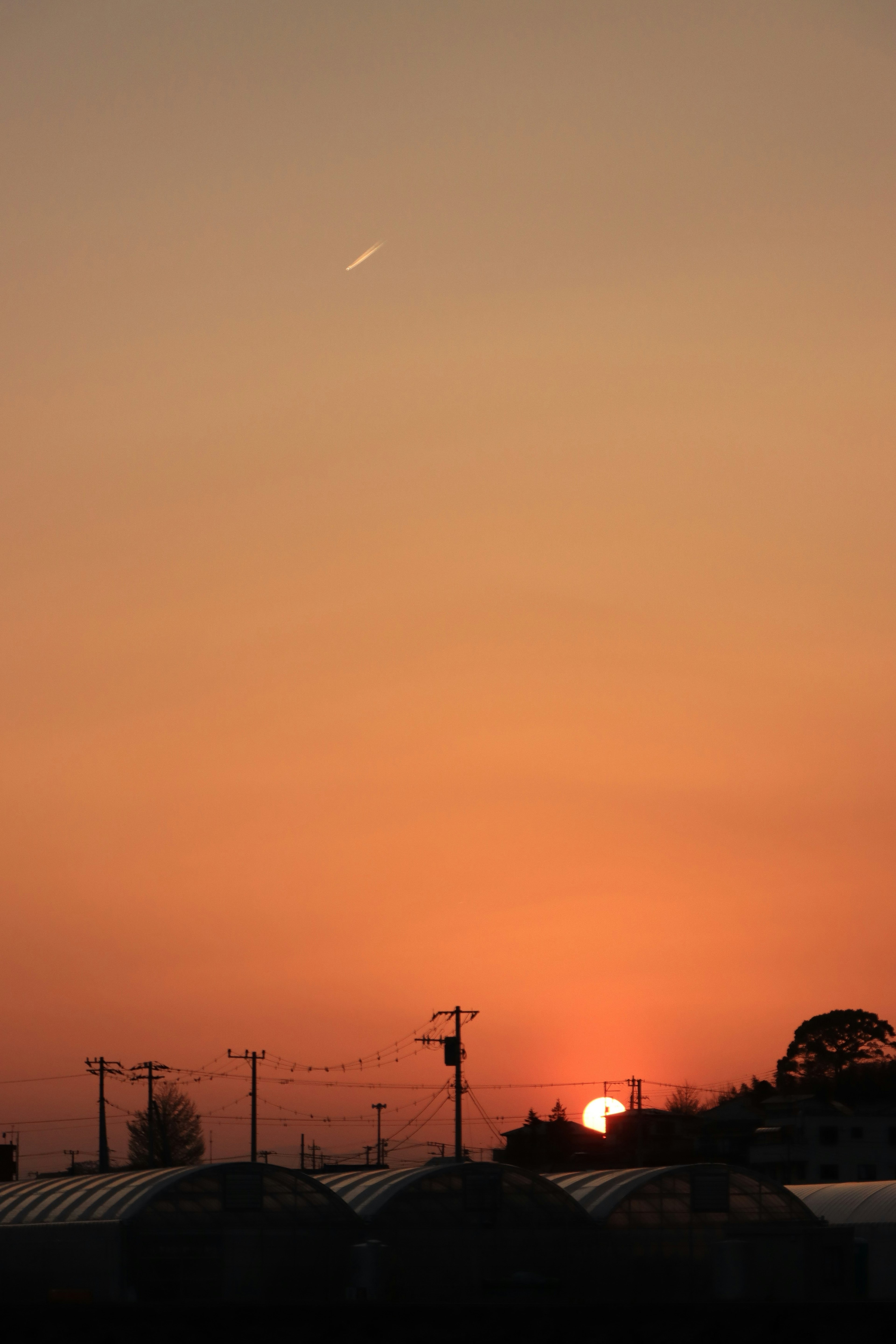 Oranger Himmel bei Sonnenuntergang mit silhouettierten Gebäuden