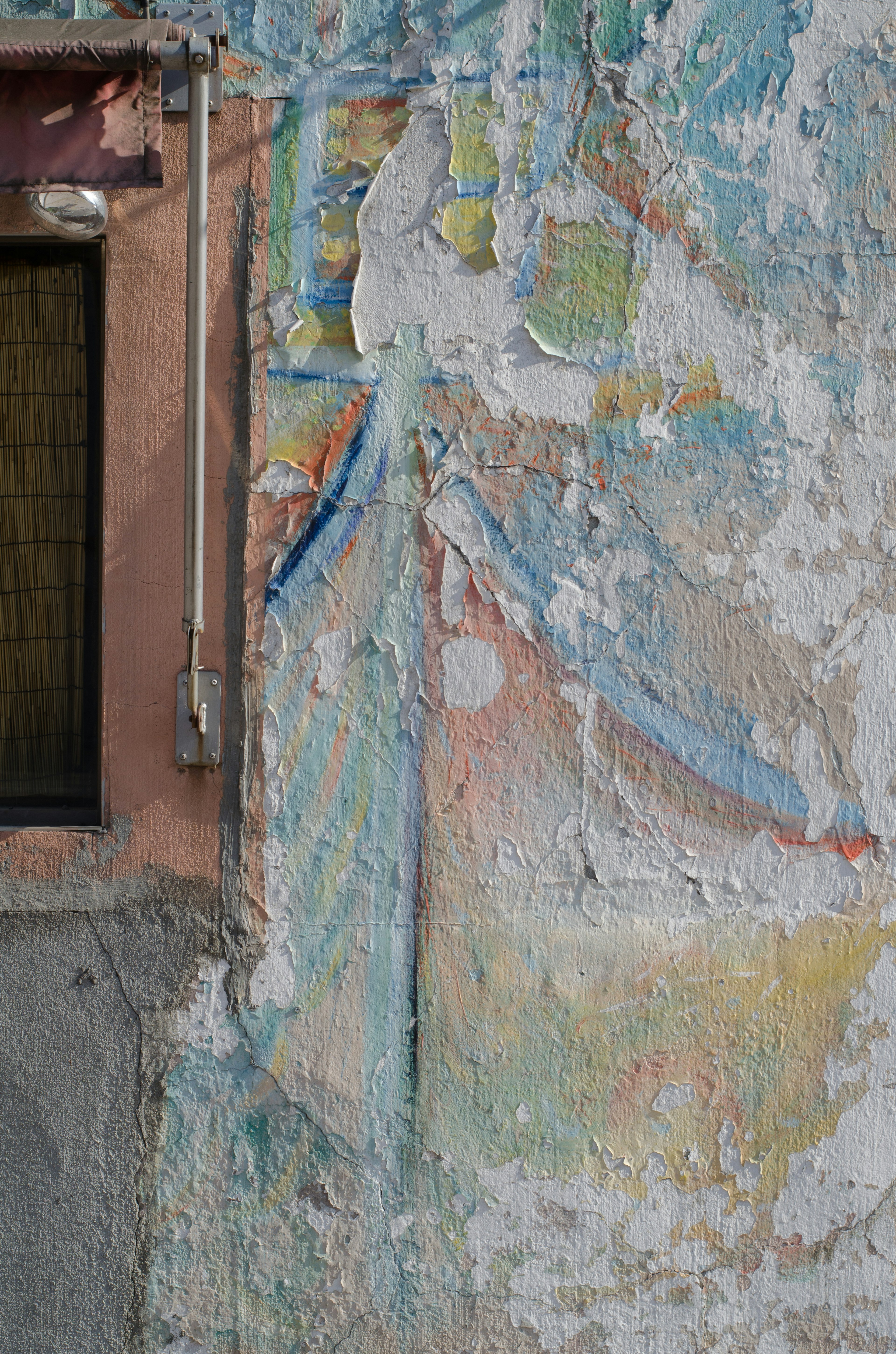 Affresco sbiadito con una finestra su un vecchio muro