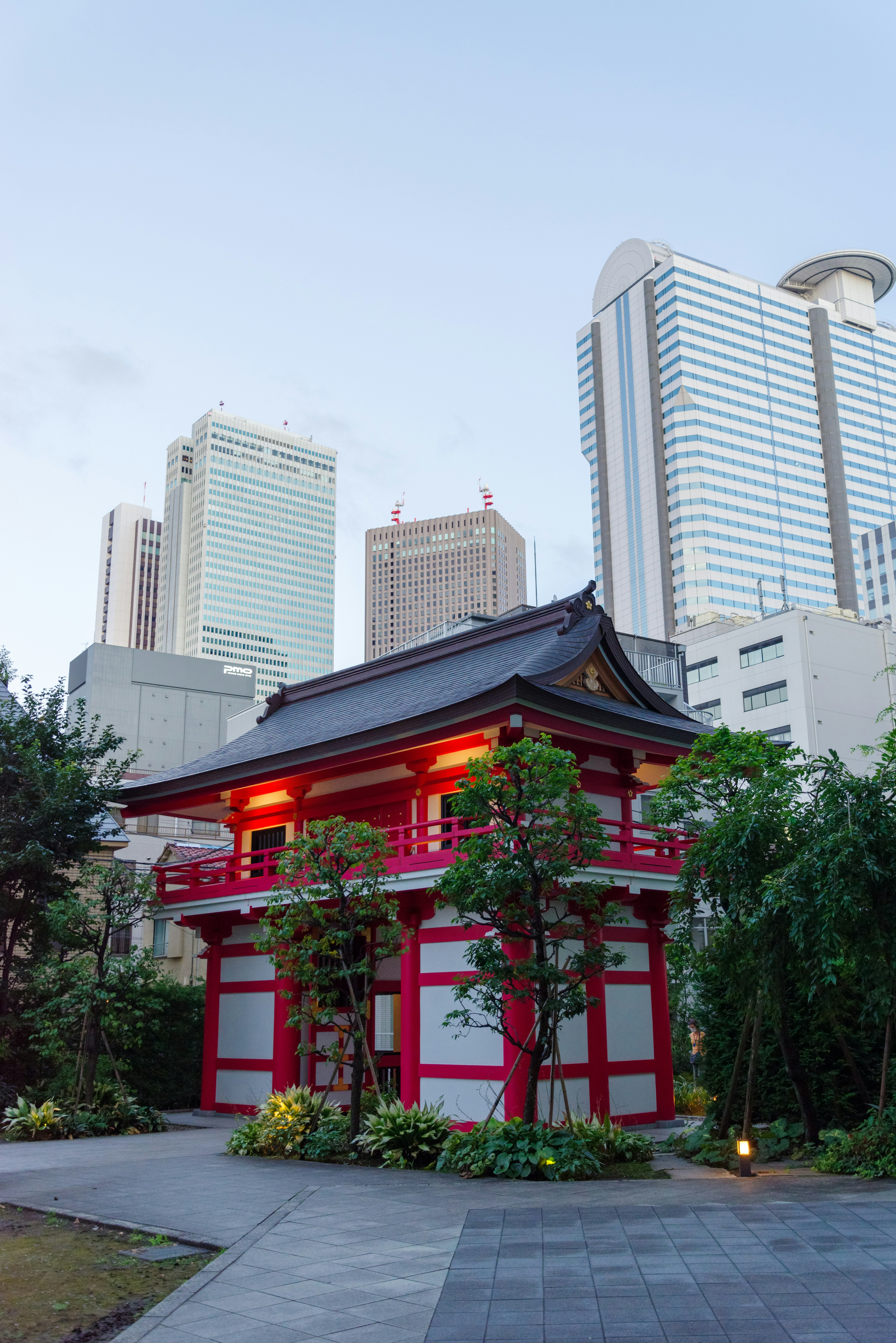 Edificio japonés tradicional en rojo con rascacielos modernos de fondo