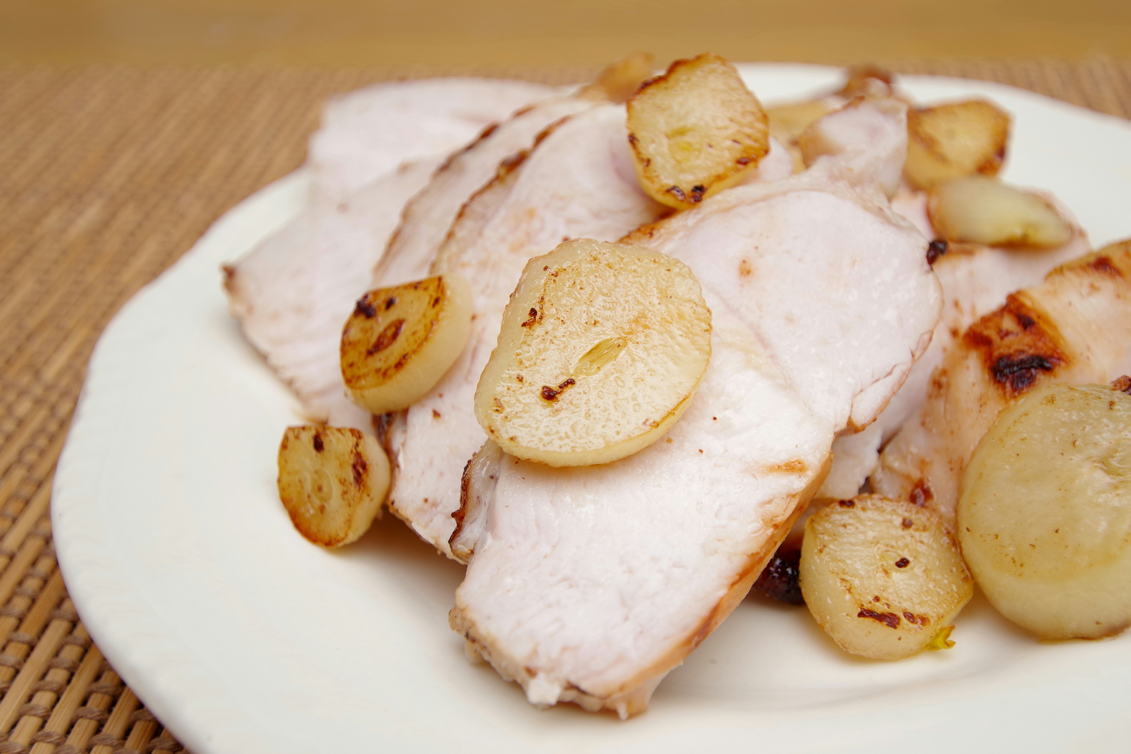 Poitrine de poulet tranchée servie avec des oignons sautés