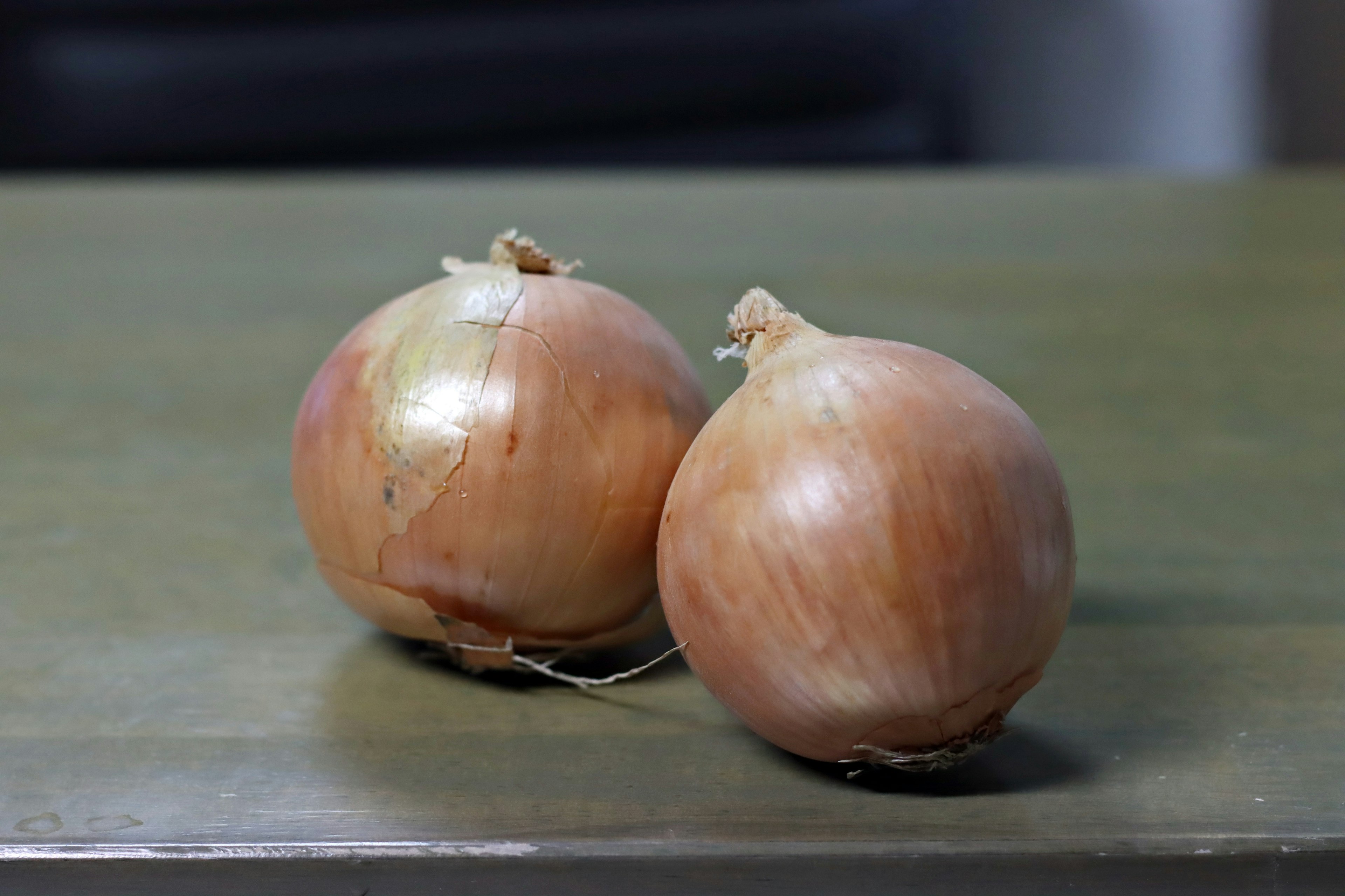 Two onions placed on a green table