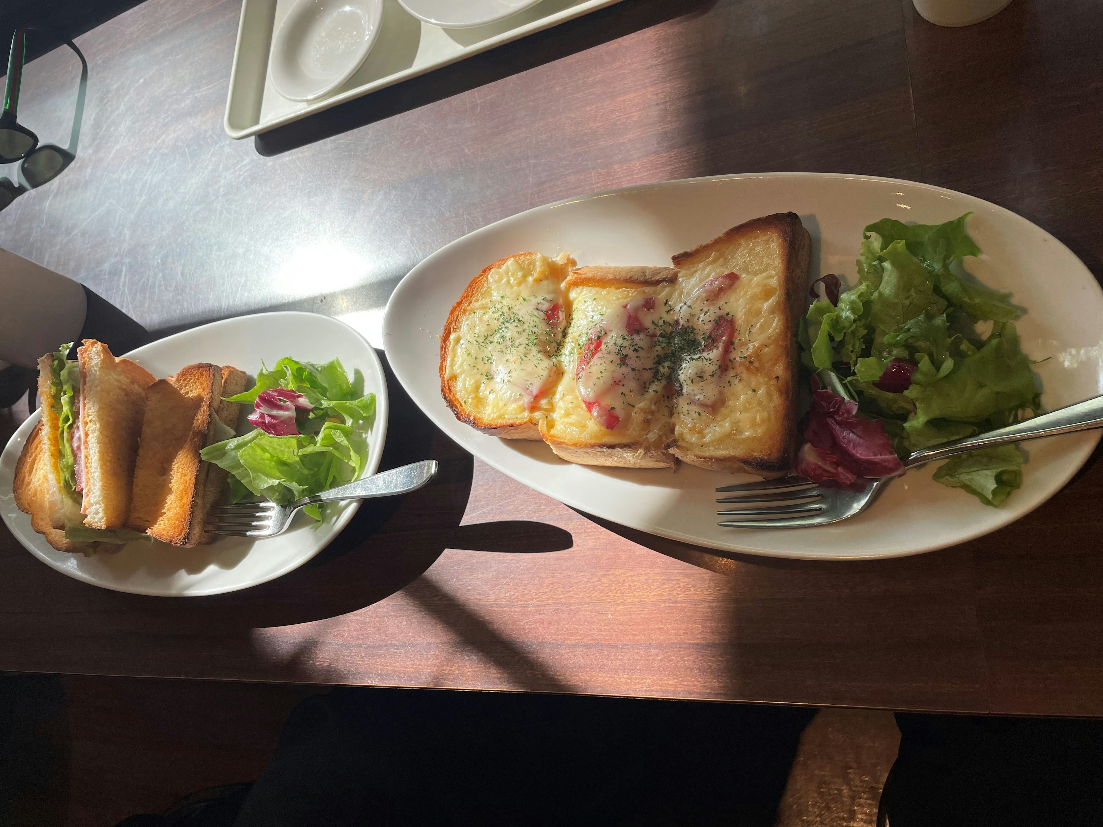 Sebuah hidangan dengan piring roti bakar yang diberi topping dan salad samping