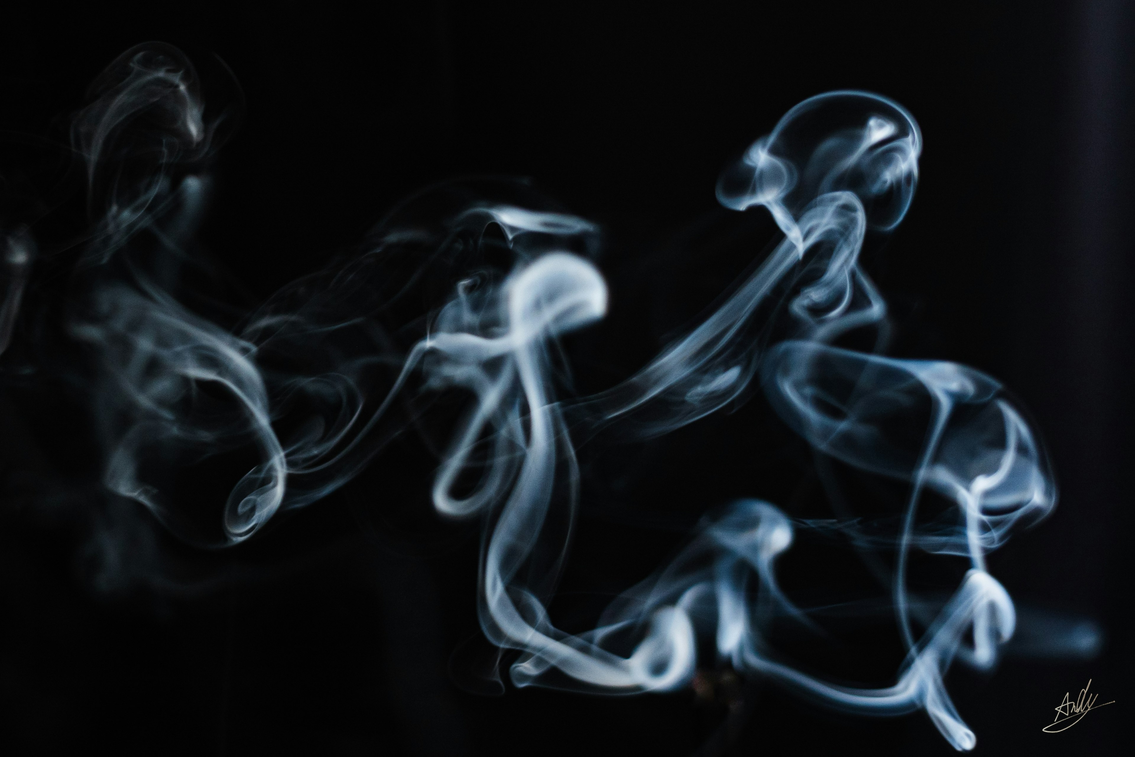 Artistic blue-white smoke swirling against a black background