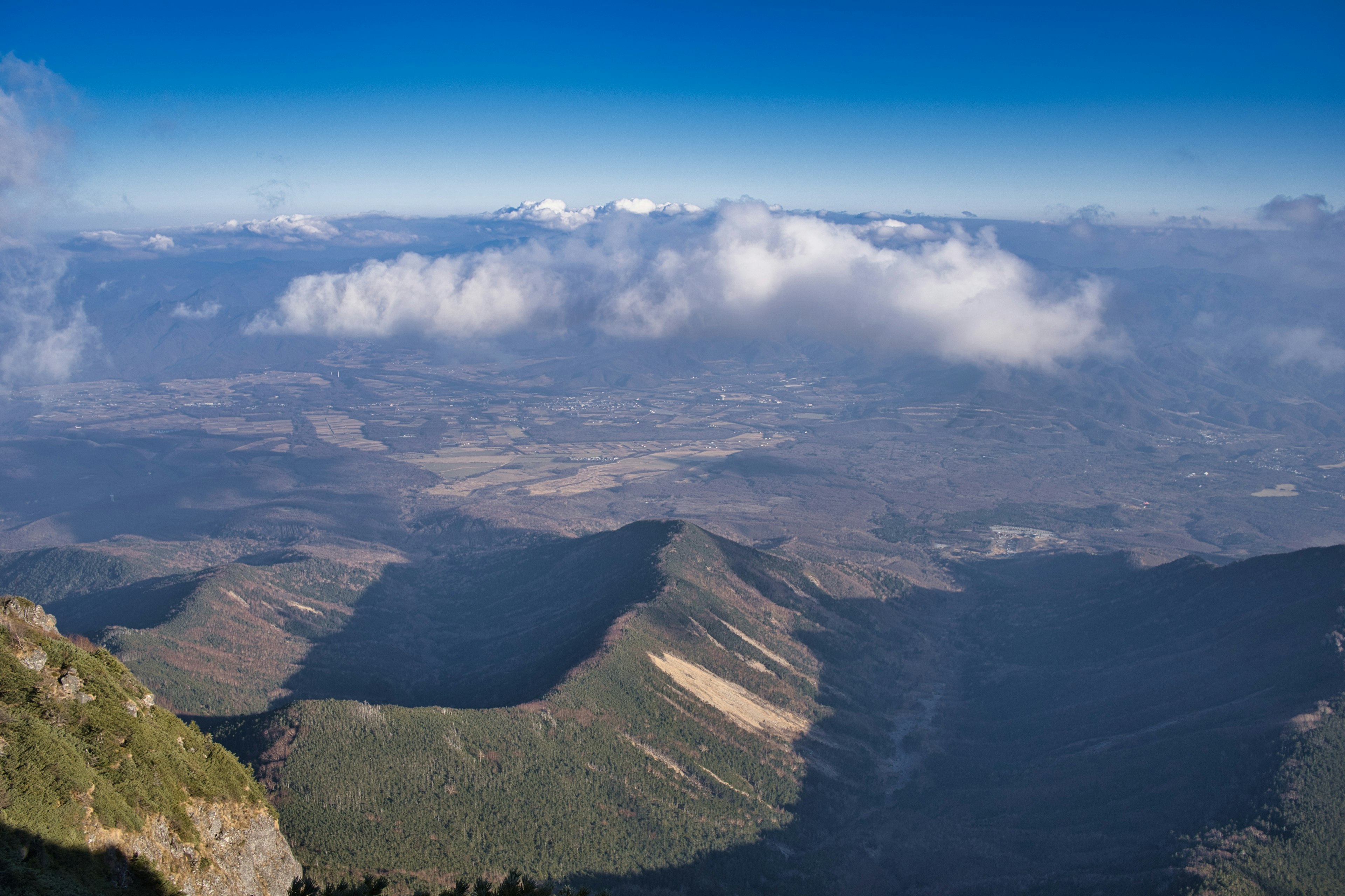 Mountain landscape under a clear blue sky with clouds