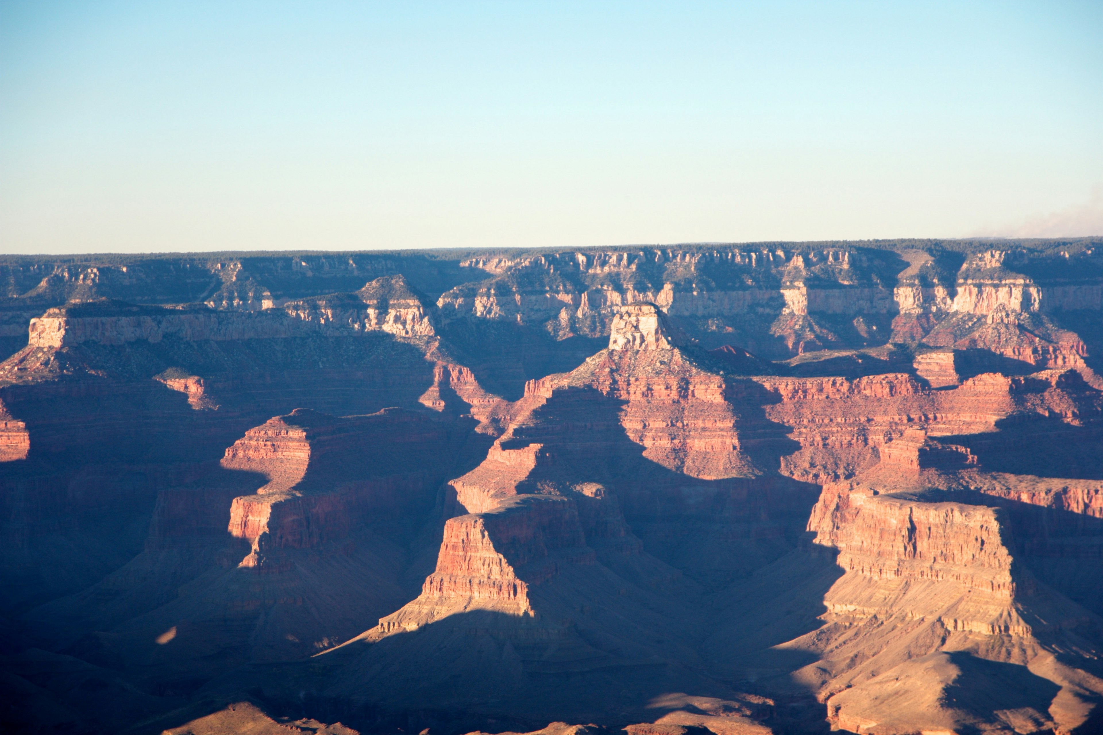 Paesaggio del Grand Canyon con formazioni rocciose rosse e cielo azzurro