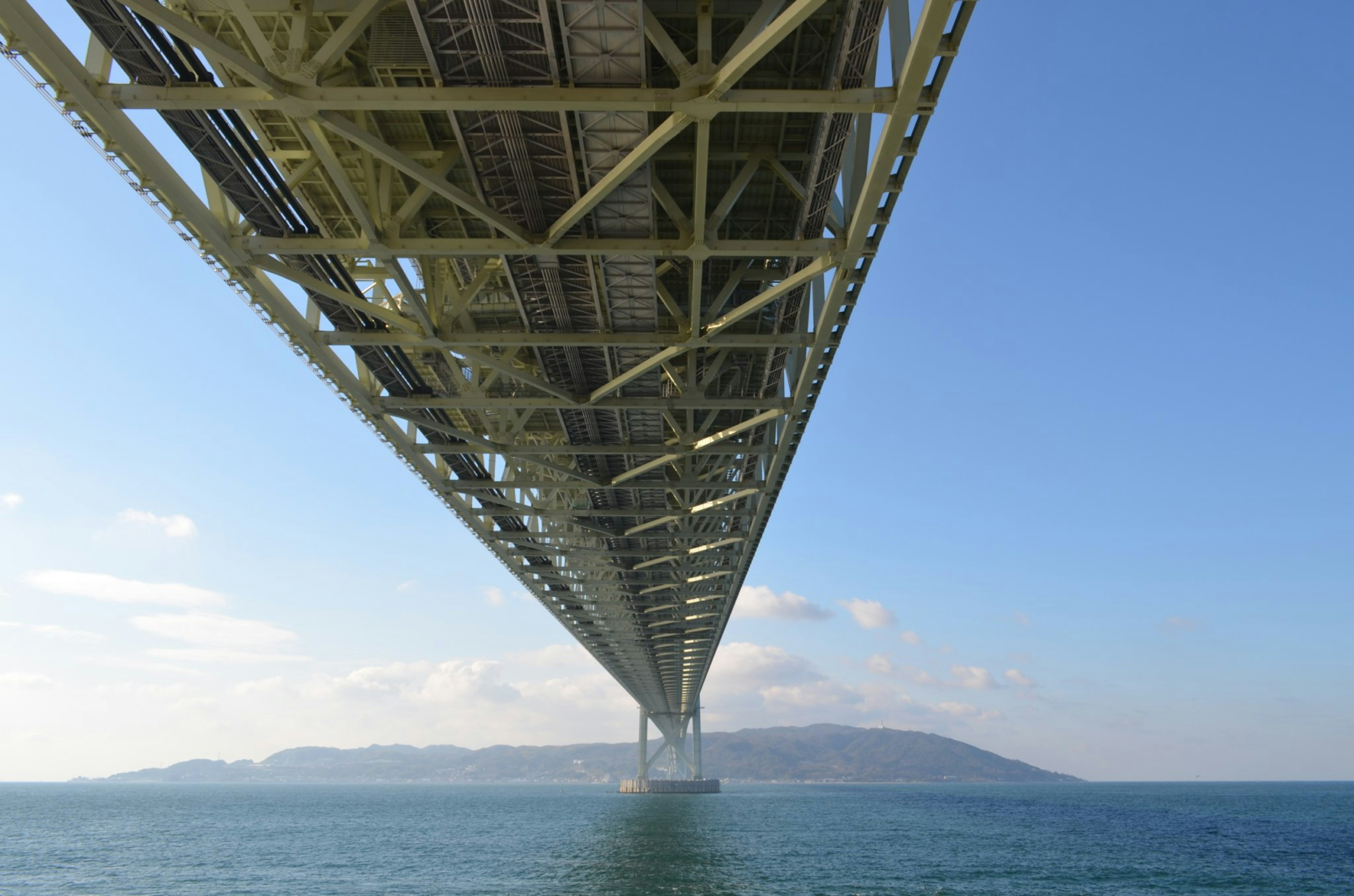 Vue depuis le dessous d'un pont avec ciel bleu et eau