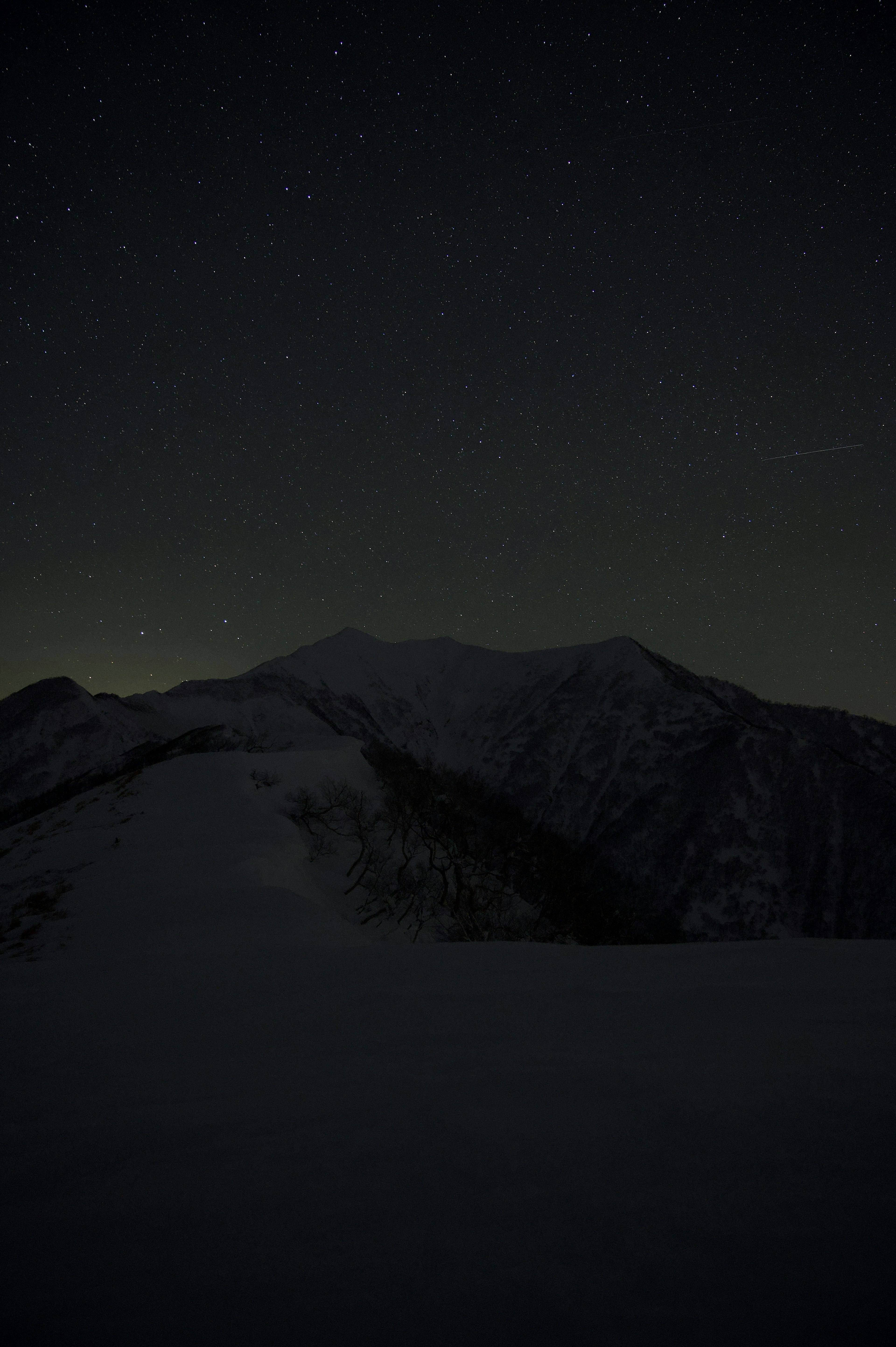 星空の下にある雪に覆われた山の風景