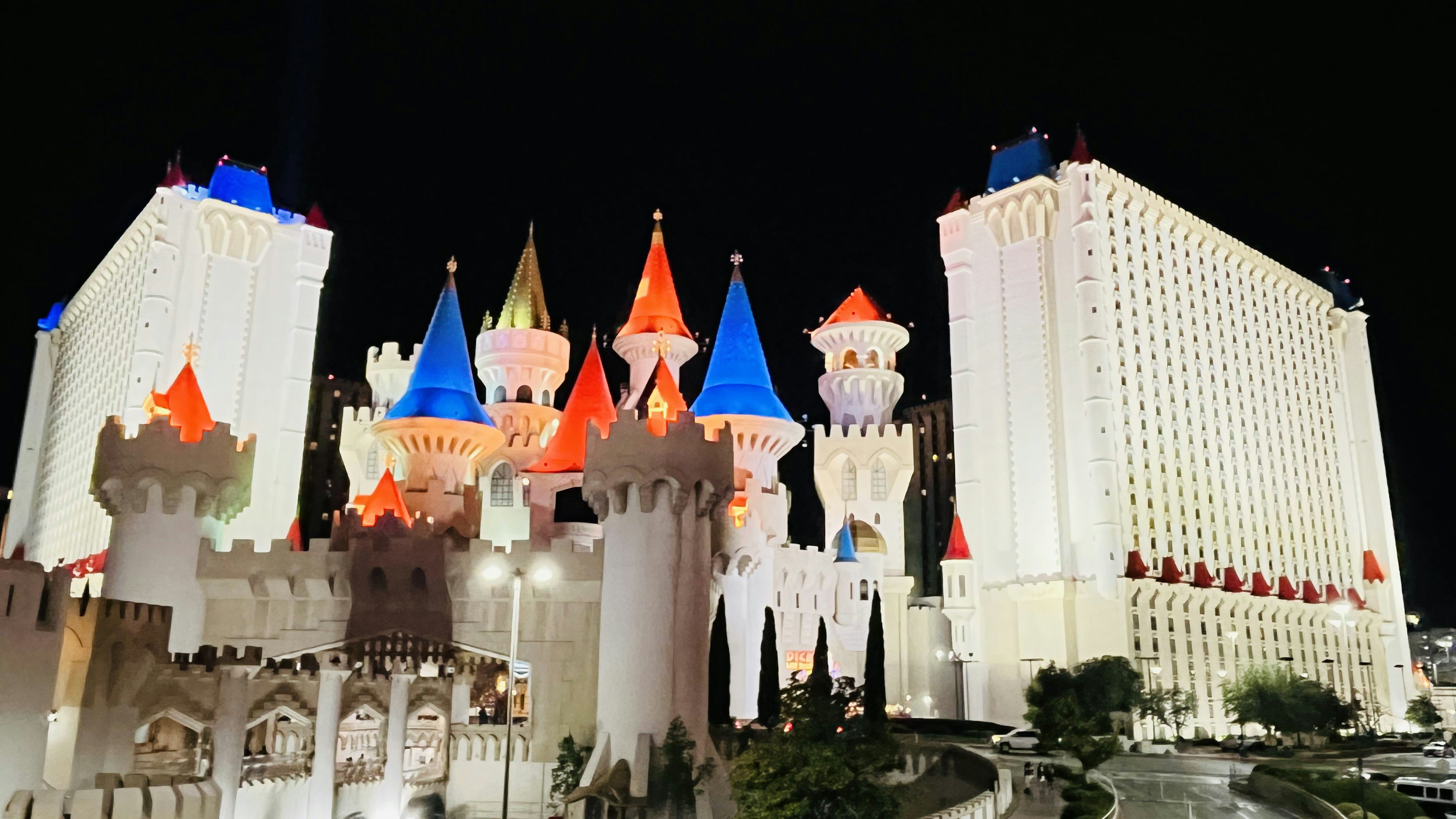 Eksterior berwarna-warni Hotel Excalibur di Las Vegas di malam hari dengan menara yang diterangi