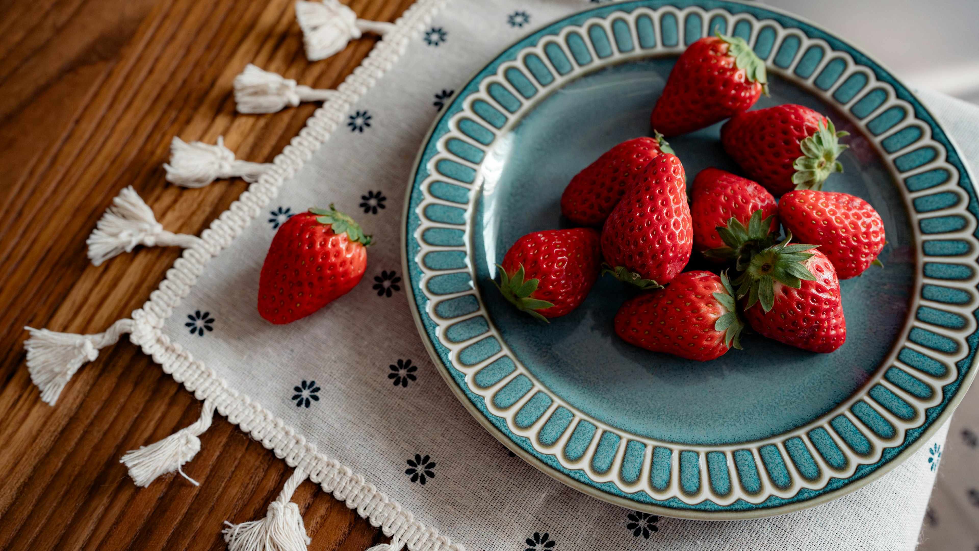 Immagine di fragole fresche disposte su un piatto blu