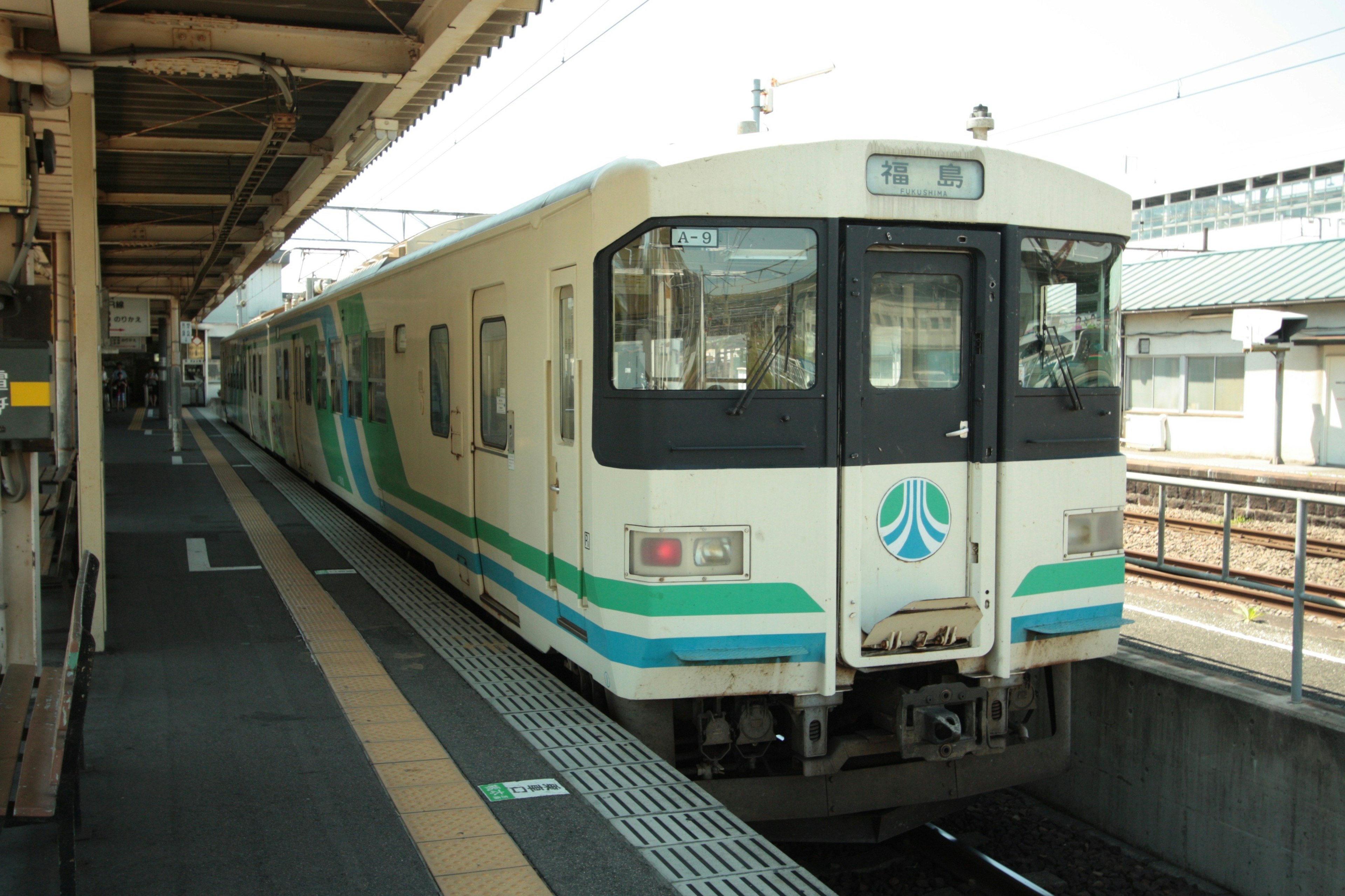 青と白のデザインの列車が駅に停車中