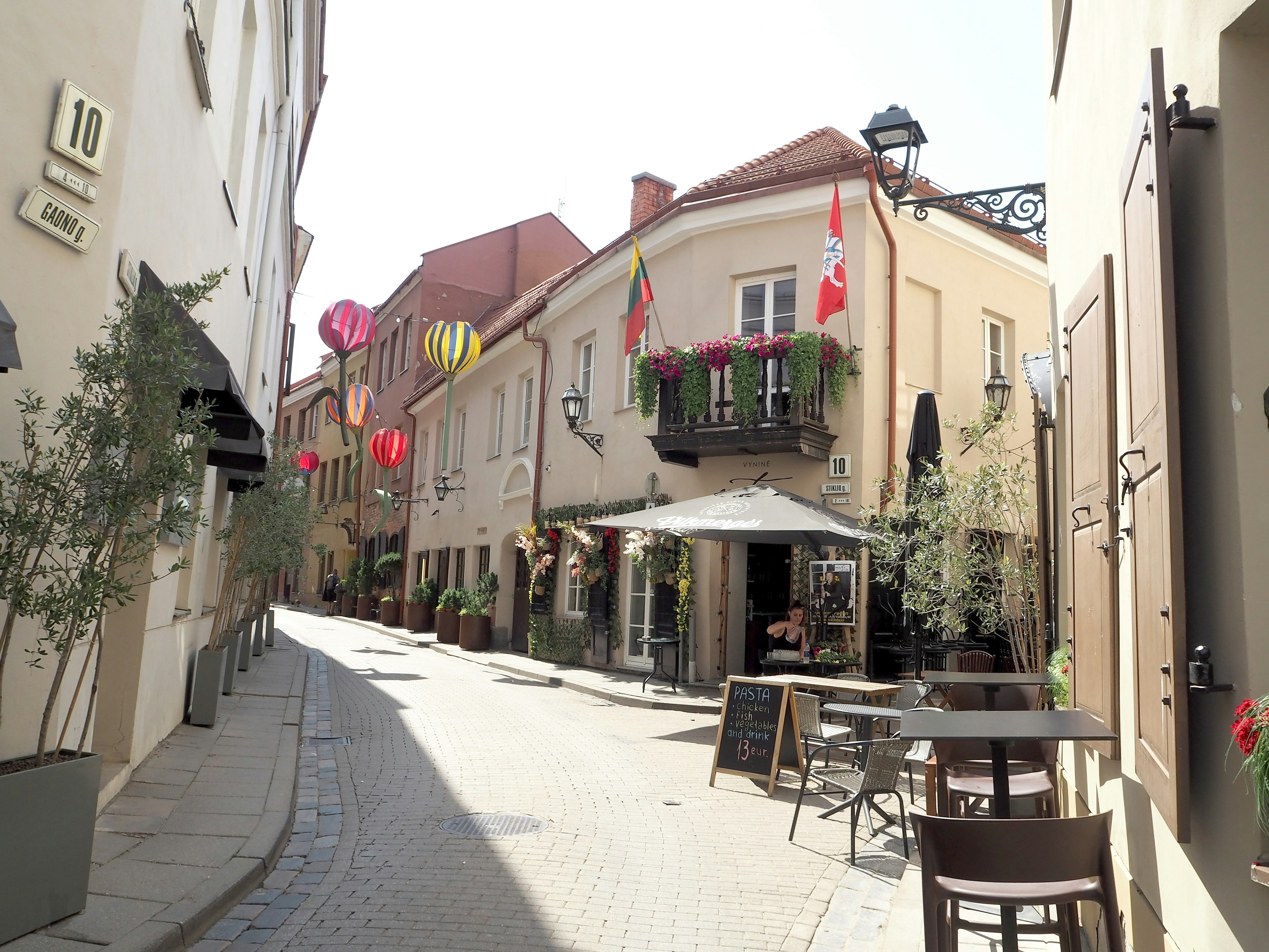 Charming street featuring colorful lanterns and outdoor seating at cafes and restaurants